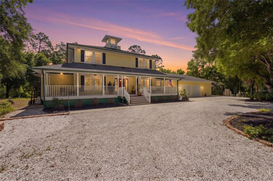 Set behind a private gate and framed by nearly 4 acres of lush landscape, this one-of-a-kind farmhouse estate offers space, character, and versatility rarely found in today’s market. Pulling into the circular driveway, the setting feels intentional with mature oak and palm trees, new fruit trees, and natural wooded buffers which create a sense of quiet separation while being just minutes away from everyday conveniences and Gulf beaches. The home itself immediately stands out with its expansive wrap-around front porch, an inviting extension of the living space and the perfect place to unwind, entertain, or simply take in the peaceful surroundings. Thoughtfully designed and meticulously maintained, this residence offers over 3,200 square feet under air with 4 bedrooms, 4 full baths, and a flexible Florida room that easily functions as a 5th bedroom, office, or private guest retreat. Inside, the home reflects a curated, relaxed aesthetic with warm textures, natural tones, and modern finishes. The main living area is spacious and comfortable, anchored by a wood-burning fireplace and enhanced by new engineered hardwood flooring. Sliders open to the screened lanai, seamlessly connecting indoor and outdoor living while overlooking the private backyard with a hammock area and fire pit, ideal for evenings under the stars. The kitchen has been tastefully updated with quartz countertops, tiled backsplash, newer appliances, and a generously sized breakfast bar perfect for gathering. Off the kitchen is a highly functional utility wing featuring a second refrigerator, a separate 9x9 pantry room complete with built-in shelving, cabinetry, and a deep freezer. The large laundry room (26x7) provides ample space for additional storage. The first floor layout includes a private bedroom suite with updated bath and French door access to the Florida room, offering flexibility for multigenerational living or guests. Upstairs, the primary suite provides a quiet retreat with two walk-in closets (one currently styled as a dressing room) and a beautifully updated bath featuring dual vanities and an effervescent soaking tub. Two more bedrooms and another updated full bath with a deep soaking tub and shower complete the upper level. All upstairs bedrooms feature oak wood flooring, adding warmth and continuity throughout. Beyond the main residence, the property continues to deliver. The expansive yard has hidden trails beneath a canopy of oaks and cleared areas for gathering. A detached 725 square foot outbuilding with electric offers endless possibilities, ideal for a workshop, studio, or hobby space. The oversized garage accommodates two vehicles with additional room for storage, tools, or recreational equipment. Additional features include a whole-house reverse osmosis water system (2024), hot water heater (2021), upstairs AC (2020), and a brand-new downstairs AC (2025). The property is fully fenced, zoned agricultural, and allows for horses, providing flexibility for a variety of lifestyles. Despite its private, tucked-away feel, this location remains highly accessible. Approximately 25 minutes to Gulf beaches and convenient to shopping, dining, and North Port amenities. Not located in a flood zone. Extensively improved with nearly $150,000 in upgrades, this is a rare opportunity to own a property that offers both function and personality, where indoor comfort meets outdoor freedom, and every space has been designed to be lived in and enjoyed.