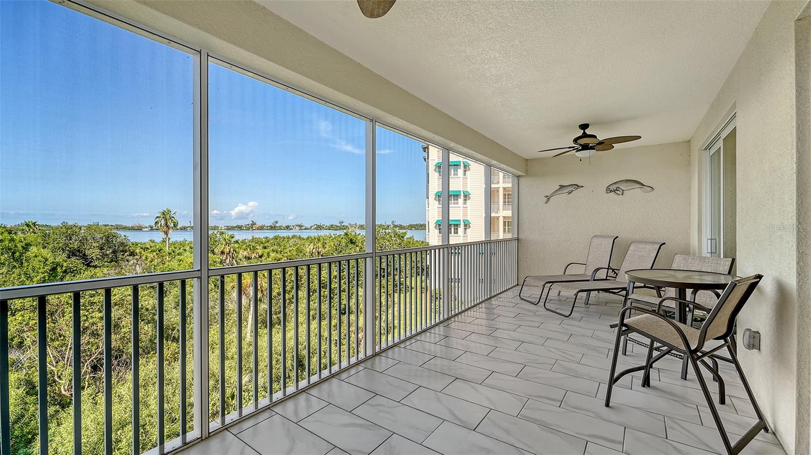 WHAT A VIEW! Prepare to be captivated by jaw-dropping sunsets from your oversized, private, screened-in balcony, offering unobstructed vistas across Little Sarasota Bay to the peaceful barrier island of Casey Key. Welcome to Edgewater at Hidden Bay — a gated, 12-acre resort-style community perfectly positioned between the charm of historic Venice and the cultural vibrancy of downtown Sarasota. This impeccably maintained three-bedroom, two-bathroom plus den residence offers panoramic water views and an easy, elegant coastal lifestyle. Step inside to a bright, open-concept layout with a spacious living and dining area — perfect for entertaining or relaxing while soaking in the scenery. The gourmet kitchen is a chef’s dream, featuring stainless steel KitchenAid appliances, granite countertops, 42” real wood cabinetry, counter-height seating, and abundant storage. Coffered ceilings and 5-inch baseboards add refined architectural detail throughout. The expansive primary suite is a tranquil retreat with direct access to the balcony, dual walk-in closets, and a spa-inspired bathroom boasting dual vanities and a glass-enclosed shower. A split bedroom layout offers optimal privacy, while the full-size laundry room includes built-in cabinets and a sink for added convenience. Additional highlights include Kohler plumbing fixtures, hurricane-impact windows and doors, and an abundance of natural light throughout. Offered furnished, this home is move-in ready. Edgewater at Hidden Bay delivers exceptional amenities: a heated resort-style pool and spa, clubhouse with catering kitchen and library, fitness center, tennis and pickleball courts, kayak launch and storage, scenic boardwalk through lush mangroves, and a private fishing pier (currently being rebuilt). Enjoy unmatched access to award-winning beaches (just 6.5 miles to both Siesta Key and Nokomis Beach), Bay Street Park, Legacy Trail, Oscar Scherer State Park, shopping, dining, marinas, golf, and premier medical facilities. This is more than a home — it’s a lifestyle. Schedule your private showing today and discover the very best in waterfront living.