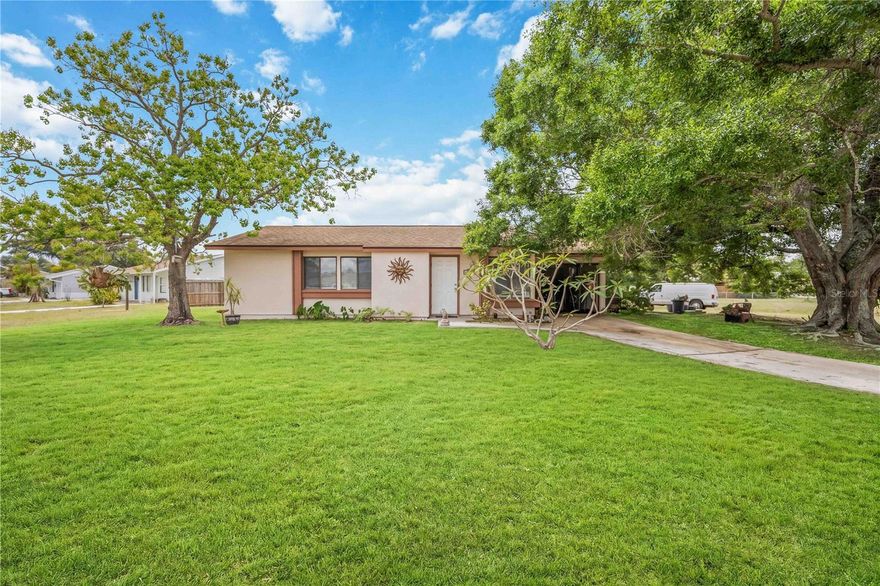 Nestled on a spacious and oversized corner lot at the intersection of Kenwood Dr. and Elmwood Rd., this charming 2-bedroom, 2-bathroom single family home delivers the perfect blend of comfort, privacy, and Florida lifestyle. A stunning heritage oak tree anchors the front yard, providing gorgeous curb appeal and natural shade that greets you the moment you arrive. The corner windows in the front of the home frame a picturesque view of this beautiful tree, filling the interior with warmth and character.
Step inside to find a bright and inviting layout featuring a generous Florida room with sliding glass doors that open out to an oversized backyard. Whether you are dreaming of a future pool, creating a space for entertaining, or simply enjoying the outdoors, this yard has the room to make it happen. A greenbelt lines the back edge of the property, offering a natural privacy buffer, while fencing along the neighboring property adds an extra layer of seclusion.
This home is connected to city water and sewer, and major systems have been updated for peace of mind. The roof was replaced in 2019, the HVAC system was updated in 2016, and the electrical main panel was replaced in 2017. Most windows are fitted with hurricane shutters installed in 2019, keeping you prepared and protected through storm season.
With a 1-car garage, a prime corner lot location, and a long list of key updates already completed, 6911 Kenwood Dr. is a fantastic opportunity to own in one of North Port's established neighborhoods. Schedule your showing today before this one is gone.
