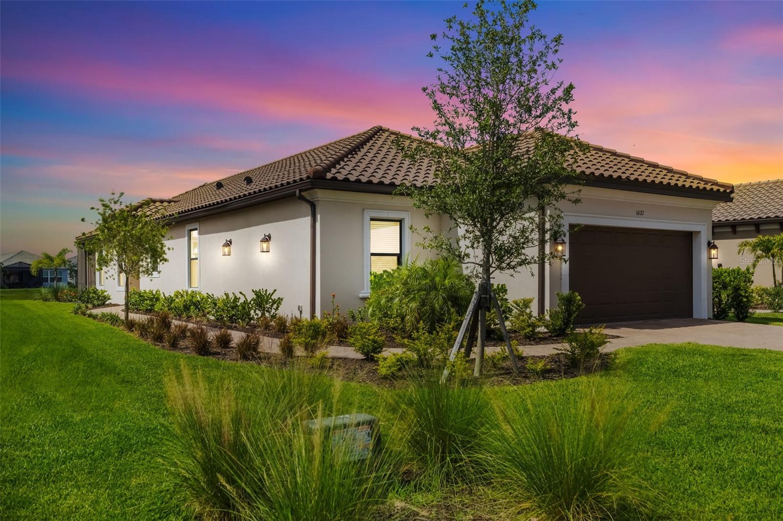 NEW IMPROVED PRICE!!! LIVE the GOLF dream NOW in this IMMACULATE CUSTOMIZED AREZZO HOME! With over $30,000 in premium homeowner upgrades, this move-in-ready gem is just STEPS from the Culinary Center, Golf Clubhouse, and world-class Amenity Center. Bring your golf clubs—your new lifestyle awaits at 16127 Fortezza Drive! Welcome to your GOLF-DEEDED Florida dream home in highly sought-after Esplanade at Azario in Lakewood Ranch! This like-new, stunning 3-bedroom, 2-bathroom Arezzo model by Taylor Morrison offers a perfect blend of luxury and comfort, with thoughtful upgrades throughout. As you enter, you'll be greeted by spacious, open living areas ideal for both entertaining and relaxing. The gourmet kitchen is a chef’s delight, featuring upgraded stainless steel appliances, ample counter space, and an additional drawer for extra storage, designed to make meal preparation both enjoyable and effortless. The master suite is a true private retreat, offering a spa-like bathroom with built-in drawers for added convenience and beautiful lake view. Step outside to the extended lanai, where you can unwind while overlooking a peaceful lake, the perfect spot to enjoy Florida’s beautiful weather. Spend your mornings watching the birds or enjoying a serene view of the water. This home is filled with desirable upgrades, including a 4-foot garage extension, elegant 8-foot doors, an epoxy-coated garage floor, and pocket doors leading to the flex room. The laundry room is equipped with upgraded cabinets and a stainless-steel sink, while the dining and flex rooms feature stylish accent walls. Additional conveniences include under sink tilt-down trays in the kitchen, master bath, and laundry, as well as extra electrical outlets throughout the home. Very convenient homesite location makes for easy walking and golf cart access to Esplanade at Azario’s incredible resort-style amenities, including a clubhouse, fitness center, pool, culinary center and more. It’s all about enhancing your lifestyle in a truly exceptional community. Don’t miss the chance to make this rare home yours. Schedule your showing today and experience the perfect mix of luxury and location!