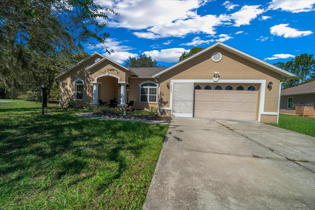 Welcome to 5365 SW 111th Lane Rd in Ocala, FL, a 3-bedroom, 2-bathroom home located in the desirable Marco Polo Village II community. Built in 2003, this home offers just under 1,900 square feet of comfortable living space on nearly half an acre. From the moment you walk in, you’ll notice the bright and open layout featuring cathedral ceilings and plenty of natural light. The spacious living area flows seamlessly into the large eat-in kitchen, which offers ample cabinet space, a breakfast nook, and room for entertaining family and friends.
The split-bedroom floor plan provides privacy for the primary suite, complete with dual vanities, a soaking tub, a separate shower, and private access to the screened-in porch — the perfect spot to relax and enjoy your morning coffee. The home also features tile and laminate flooring throughout, an indoor laundry room, and a roomy two-car garage for added convenience.
Outside, you’ll find a large, fenced backyard with plenty of space for pets, gardening, or simply enjoying Florida’s beautiful weather. The backyard also includes a deck, perfect for gatherings, barbecues, or outdoor entertaining. The screened porch overlooks the backyard and offers a peaceful place to unwind. With low HOA fees, this property provides a relaxed lifestyle while still being close to shopping, restaurants, I-75, and outdoor recreation like the Florida Greenway trails.
This Ocala gem truly combines comfort, value, and location — making it the perfect place to call home. Schedule your private showing today!