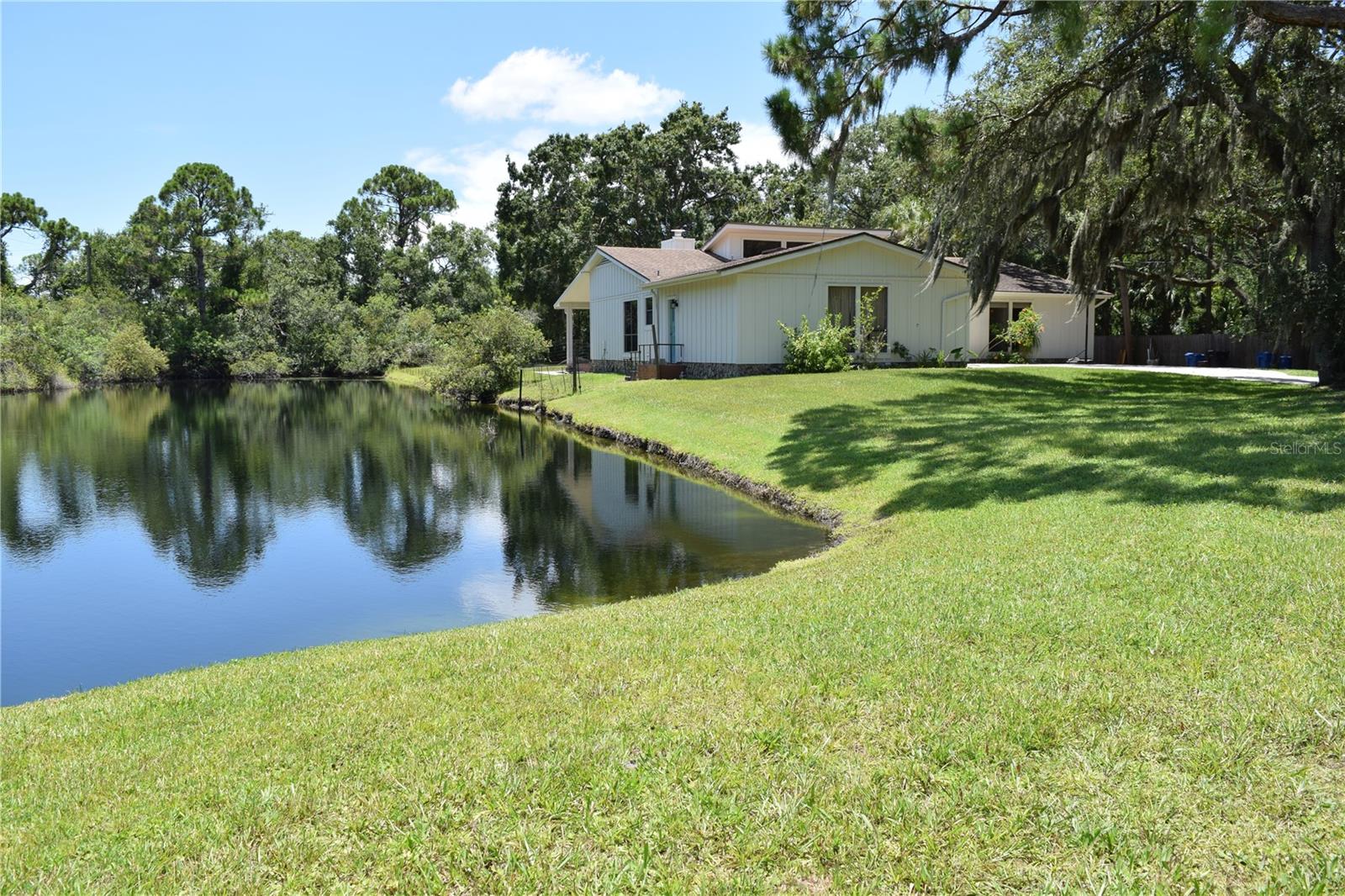 Beautiful Great Room open plan home in Twin Branch Acres, an equestrian community near the Oldsmar Flea Market and Tampa Bay Downs on over an acre with a private pond. Exterior of home has just been updated and painted. Huge back and front yards, long driveway with room to park a boat or possibly your RV. Renovated in 2019, the kitchen features a huge island with quartzite counters, cooktop, lots of cabinets, large drawers. Double wall ovens, built-in pantry storage, eat-in space in kitchen. Great room plan with soaring ceilings and large windows, luxury vinyl-plank wood-look flooring throughout, wood-burning fireplace. Spacious master bedroom, large bathroom with garden tub, double sink vanity, separate shower, huge master walk-in closet. Large laundry room with cabinet storage and sink. Bedrooms 2 and 3 are a good size with nice closets. Covered rear porch. Oversized garage, workshop/storage shed in the back yard, parking a boat or RV is allowed. Wood privacy fence along the west property line. Pets allowed on an individually approved basis. Room sizes are approximate.
