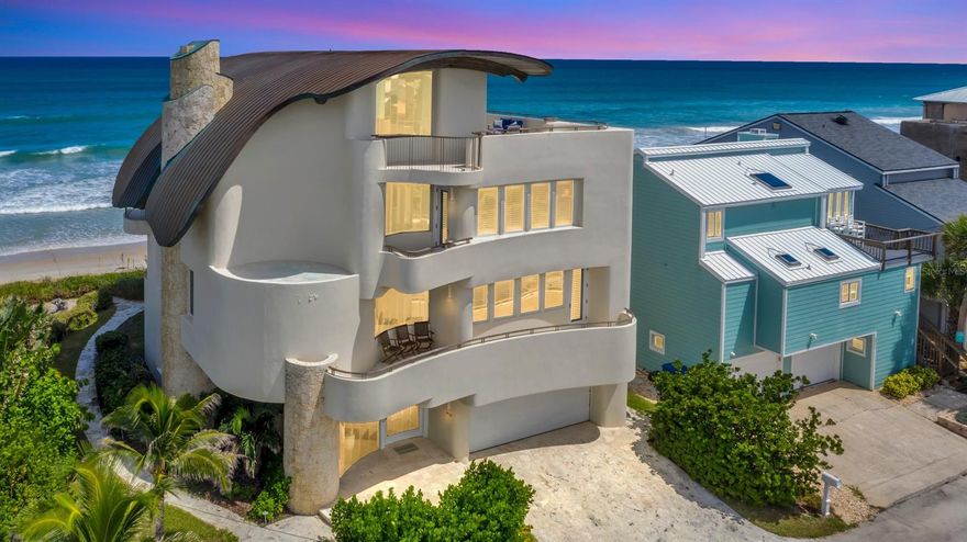 This stunning oceanfront property in NSB offers an unparalleled escape with breathtaking views of both the ocean and the Intracoastal Waterway. The home itself is a masterpiece of architecture, perched on a promontory above the expansive beach and enchanting dunes. It stands as one of the most distinguished waterfront residences in Central Florida, seamlessly blending ethereal charm with modern amenities.
Inspired by the natural beauty of the oceanfront location, the design captures the essence of the waves and the ocean's power. The structure's exotic shape and poetic details, complemented by imaginative amenities, make it truly exceptional. Features include a luxurious master suite, wet bar, theater room, two keystone fireplaces, and a fully equipped professional chef's kitchen with custom imported cabinetry from England and top-tier stainless-steel appliances (Sub-Zero, Miele, Thermador).
The interior is anchored by a dramatic four-story travertine spiral staircase, leading to overlook lofts on all levels and a roof terrace with panoramic views of the ocean to the east and the river to the west. The curving roof structure, constructed with laminated beams, timber wood decking, and copper cladding, adds to the home's unique appeal. Teak and stainless steel are used for exterior railings and cabinetry. The design seamlessly connects the interior and exterior with indigenous Florida Keystone, hand-textured plaster, and expansive segmented butt-joined glass.
This extraordinary beachfront residence combines the essence of California's Gold Coast, Southampton, NY, and Palm Beach. If situated in any of those locales, its market value would be five times that of NSB. This charming beach town offers local culture, year-round beach activities, festivals, parades, excellent dining, boutique shopping, art, and a beautiful sandy shoreline. ;Water: City