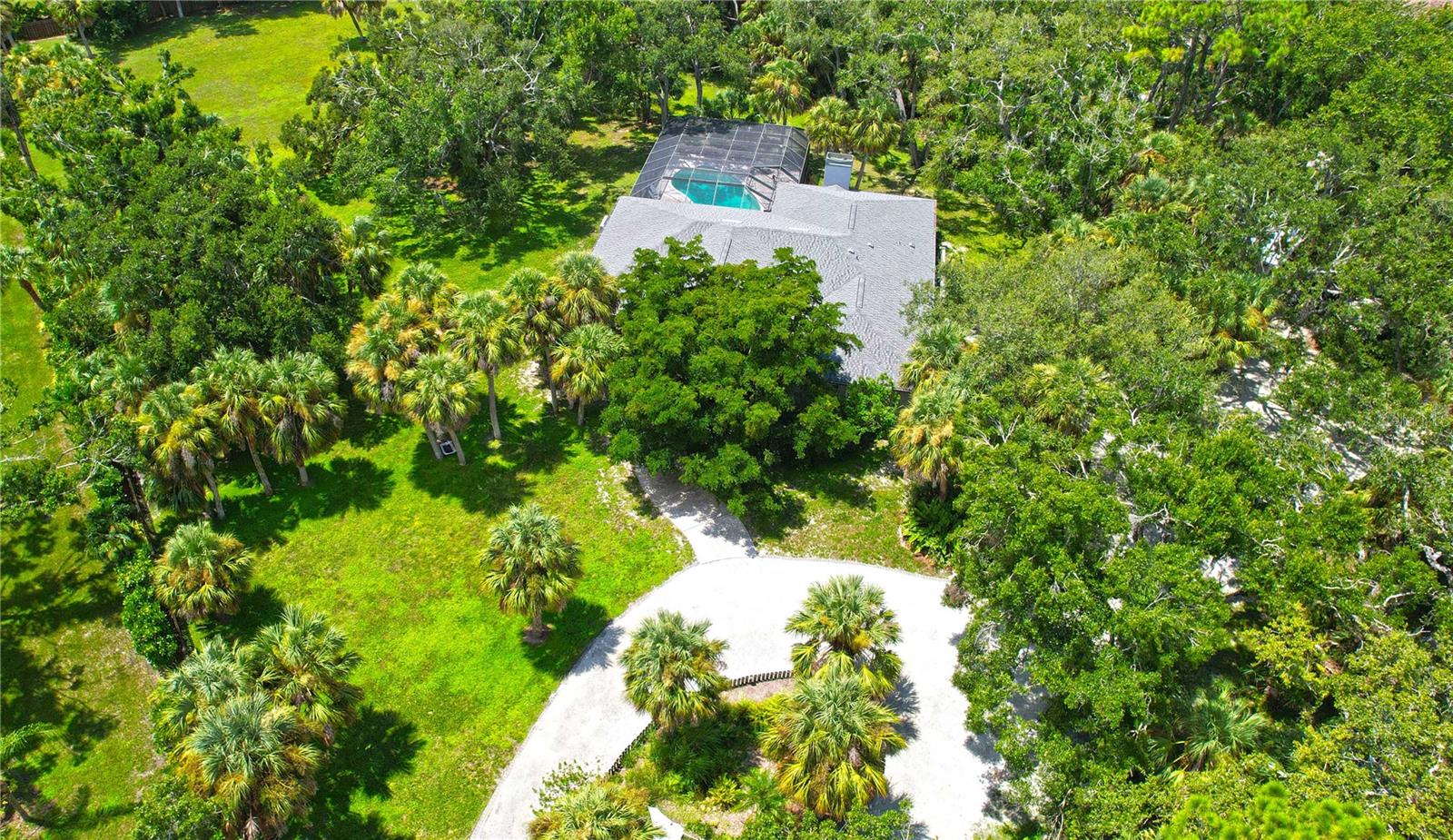 Discover a truly unique opportunity with this private 1.9-acre property offering freedom with no deed restrictions, Horses allowed, no HOA, and no flood insurance required. Just minutes from the new Sarasota Memorial Hospital in Nokomis, Nokomis Beach, and historic downtown Venice, this home combines privacy with convenience. The residence features three bedrooms and three full bathrooms, including a potential mother-in-law suite with its own entrance including an office or possible fourth bedroom, family room, bathroom, and an oversized storage room with custom floor-to-ceiling cabinetry. Recent updates include a new roof and gutters in 2024, a three-zone A/C system under warranty, and fresh exterior paint in 2021. Inside, bamboo floors enhance the living and dining areas, while outside, the grounds are fully fenced with a privacy gate. Enjoy a 36x16 pool that is nine feet deep with paver decking, under a 54x36 screen enclosure, plus a detached two-car garage and a 20x20 outbuilding for additional storage. Surrounded by serene views in every direction, this irreplaceable property offers the perfect blend of peace, space, and proximity to shopping, dining, medical facilities, and pristine Gulf beaches.
