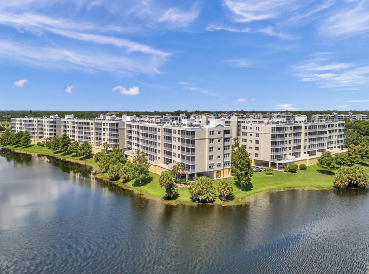 Discover the perfect blend of luxury, serenity, and unbeatable value in this stunning top-floor lakefront penthouse condo at 1200 Country Club Drive #2504. Boasting 3 spacious bedrooms, 2 bathrooms, and deeded over-sized under-building Garage 20. This private retreat offers a wonderful 180-degree panorama of pleasant, peaceful southern skies with golf views of fairways, greens, bunkers, palms, pines and wildlife on East Bay Golf Course from a wide screened lanai. The open-concept layout is enhanced by high ceilings, making it ideal for both quiet relaxation and entertaining. The owner’s suite is a private oasis with two walk-in closets, a spa-inspired en-suite bathroom featuring twin walk-in closets, two vanities, large double shower, and private water closet, plus direct access to the lanai. The split floor plan offers two additional versatile bedrooms, perfect for guests or a home office, along with a generous laundry room and extra storage. Enjoy resort-style amenities including heated pool, spa, and upgraded clubhouse, all nestled in a village-like community. Solid concrete Building Two with completed SIRS compliance gives peace of mind and no evacuation is necessary. Located just minutes from shopping, dining, parks, and the Gulf beaches. This home, building & community are very well designed, well built, carefully maintained and professionally managed. All-concrete construction, strong and solid, safe and sound, high and dry, peaceful and private. Country Club Condominiums is now a sought after and desirable Pinellas County community with increasing investment value and a great place to call either home or a home away from home. Great Community – Great Location – Great Lifestyle - Great Value – 2504 is a great price s a GREAT HOME! This penthouse delivers million-dollar views and lifestyle at a fraction of the cost. From its prime location to its thoughtful design features, this condominium is a rare gem waiting to welcome you home to experience unparalleled views, a tranquil setting, and modern convenience all in one fine property. Please don’t miss the opportunity to make a very special place yours, it really does not get much better in Tampa Bay! Make this paradise your home and embrace the beauty of penthouse living at CC 2504. CCC is truly a hidden oasis, the day and night is barely believable beauty - perhaps ask for a sunset showing to choose this as your piece of Florida. For your private tour of this exceptional opportunity-of-a-lifetime property, please call or text Broker Steve ILES any time, any day.