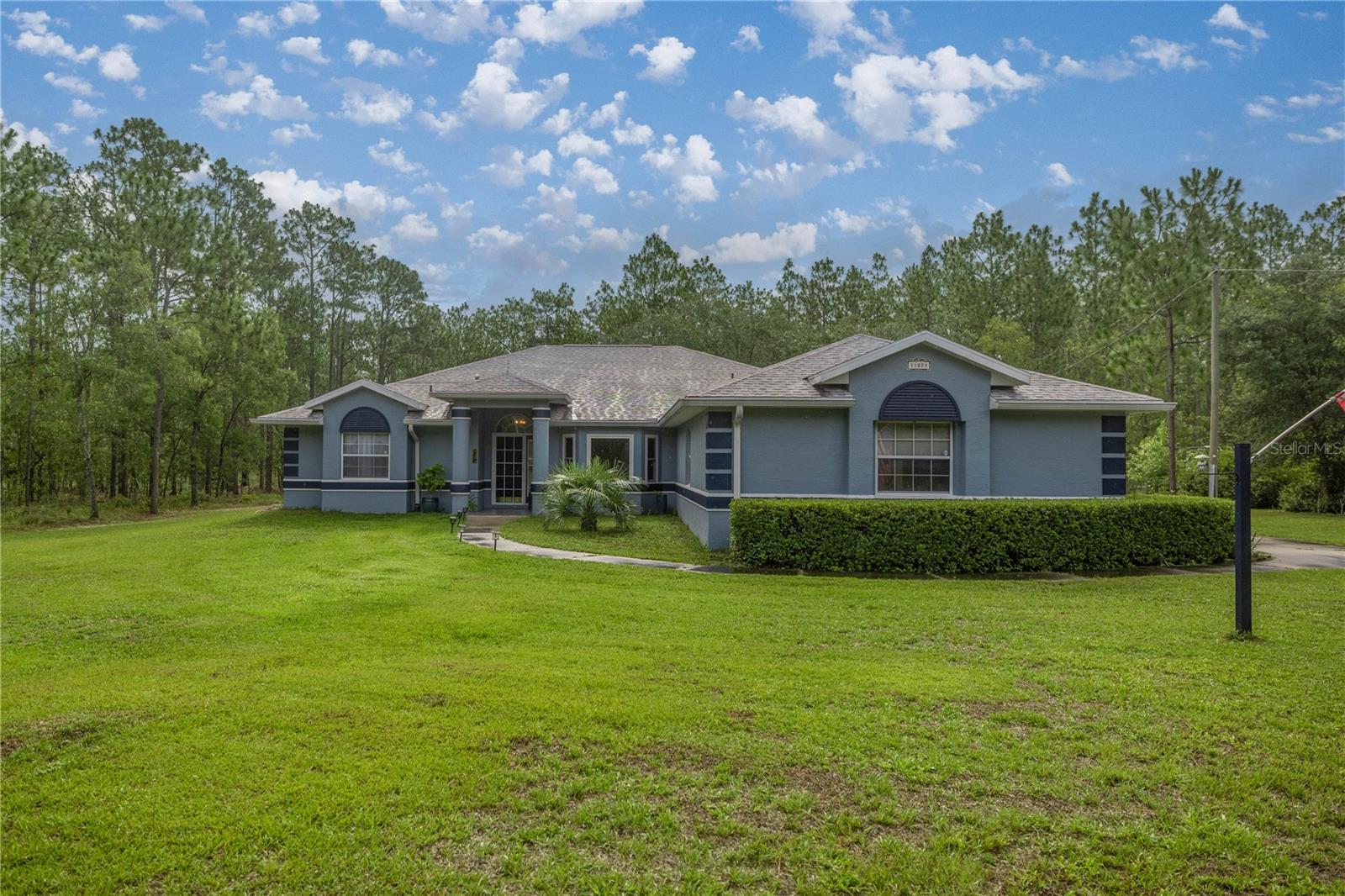 PRICE REDUCTION! Country living at its finest in Rainbow Lakes Estates. This 4 Bedroom/3 Bath POOL HOME sits on a Manicured 1.04 ACRE Lot - NO HOA, NO Deed Restrictions! Paved roads. 2017 Roof, 2021 HAVC, 2024 painted. 2557 sq ft of living area & A Salt Water inground pool w/ it’s sparkling waterfall is surrounded by a screened lanai 37 x 25 .Plus a separate enclosed, windowed lanai. This split plan offers a separate bath for 3 bedrooms. Or turn one into an ensuite! Entertain in the formal Living/dining room or in your open plan Kitchen/Family room Combo with Breakfast bar & Nook! Access & view your pool from the Master Suite (with sitting area), Livingroom, Kitchen or Bath! A Flex room, workout/workshop w/ heat/ac was constructed in the 2-car garage. Park your camper, boat under the Carport & store your lawn equipment in the utility shed. INTERACTIVE FLOOR PLAN AVAILABLE! Too much to write, see photos for list of Special Features this home has to offer.