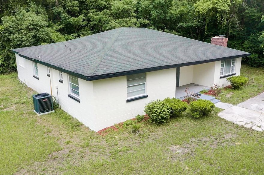One or more photo(s) has been virtually staged. Tucked away behind a wooded fence line, this property offers the kind of quiet, private living that’s hard to find — giving you space from the neighbors while still keeping you just minutes from town, shopping, dining, and Ocala’s top attractions. This fully remodeled block home combines modern upgrades, privacy, and value all in one package. Major improvements include a new A/C (2025), new water heater (2025), updated electrical, and all-new plumbing for true peace of mind. Inside, you’ll find a bright open layout with a cozy wood-burning fireplace, two master suites for added flexibility, brand-new appliances, and a bonus mud room leading to the interior laundry area with washer/dryer hookup. The home features a clean, modern design with custom touches throughout. Outside, enjoy an oversized fully fenced backyard with no rear neighbors plus a covered lanai perfect for relaxing or entertaining. With no HOA and a peaceful dirt road setting, you get that private country feel while still being close to everything.