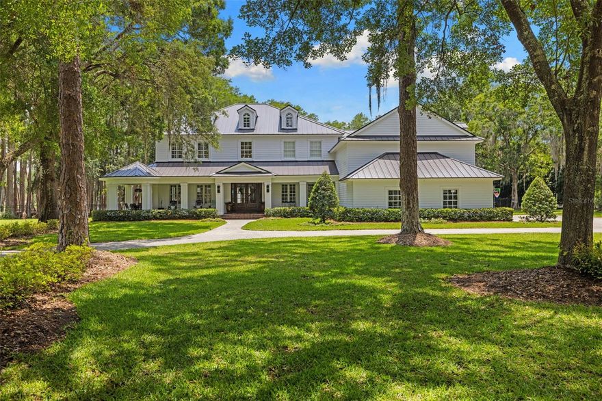 Classic, timeless, and effortlessly luxurious — welcome to your dream lifestyle at 18562 Council Crest Drive, where refined lakefront living meets the perfect Tampa Bay location. Behind the gates of the exclusive Council Crest community, surrounded by 4.69 private acres with 329 feet of frontage on Lake Martha, this extraordinary estate blends elevated design/upgrades, resort-style outdoor living, and serene waterfront beauty. The atmosphere is immediate: quiet, private, and framed by mature live oaks and cypress — worlds away from the city, yet minutes from Tampa's best dining, shopping, interstates, airports, and beaches, and zoned for top-rated Steinbrenner High School. Spanning over 7,260 SF across three levels with a private elevator, the home (built 2009) has been extensively upgraded by the sellers for elevated living and unforgettable entertaining. Beneath a newer metal roof (2022), new solid wood doors open to a foyer and a redesigned, open staircase. Rich wide-plank engineered hardwood floors flow under soaring coffered ceilings and crisp millwork. The layout offers 5 bedrooms, 4.5 baths, a 4-car garage, dual primary suites, a theater room, formal living and dining spaces, and a stunning double-island kitchen — two stone islands, custom cabinetry, brick backsplash, Wolf gas range, Wolf appliances, Sub- Zero fridge,  built-in coffee maker, and a breakfast room wrapped in custom wallpaper. The living room anchors with a custom entertainment wall and brick fireplace. Every room has been enhanced with designer-level upgrades — custom carpentry, statement lighting, designer wallpaper, renovated baths, and surround sound inside and out. The dual primary suites include a main-level suite with new brick flooring and a fully updated pool bath, plus a hotel-worthy upper suite with spa bath, freestanding tub, glass shower, dual vanities, and a massive walk-in closet with its own center island. Lifestyle spaces include a theater room, spacious guest suites, a bonus/gym room (currently the 5th bedroom), and an expansive third-floor loft that serves as an air-conditioned storage level and bonus space. Outside, the estate becomes a private resort. A spectacular 38-foot heated saltwater pool and spa with oversized sun shelf centers a travertine terrace built for entertaining. The upgraded cabana features a brick fireplace, mounted TV, speakers, tongue-and-groove ceilings, and a matching metal roof, all framed by lake views. A new private covered dock with electricity overlooks Lake Martha — perfect for fishing, sunsets, and peaceful mornings on the water. Significant investment includes a 2022 metal roof, 2022 water treatment system, newer pool equipment, tankless gas water heater, 500-gallon propane, an expanded backyard (˜38 truckloads of fill and nearly $50,000 in sod), extended lanai decking, new front doors, and extensive interior and exterior renovations throughout. Wake to peaceful lake views, fish from your private dock, and entertain under the cabana at sunset — all while enjoying complete privacy minutes from the energy of Tampa Bay. Set within a small community of just 10 homes, 18562 Council Crest Drive is more than a home; it is a fully curated luxury lifestyle of beauty, privacy, and timeless elegance in one extraordinary address.