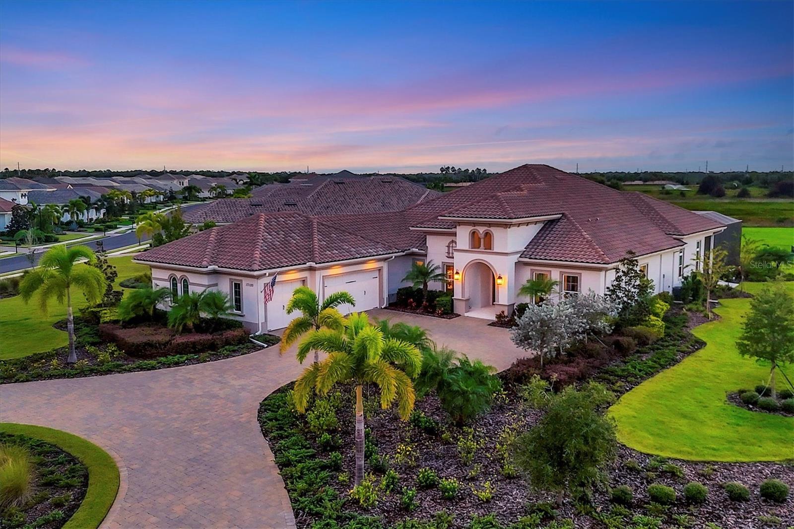 Welcome to 17120 Verona Place, a remarkable custom home that offers complete privacy in the prestigious guard-gated community, The Lake Club. The home is on one of the largest lots within The Lake Club with peaceful preserve views. This Sterling III floorplan offers four generous bedrooms, four baths and built by Stock builders. Entering through frosted double-glass front doors, you're welcomed into a grand foyer with a tray ceiling and crown molding accented by designer lighting. Beautiful tile floors flow into the expansive great room, with ceiling beams and crown molding. The dining room and great room have plenty to host friends and family. This chef’s kitchen has an oversized floating island with seating, and the space is outfitted with high-end stainless steel appliances, including a wall-mounted oven and microwave, refrigerator and a gas cooktop with oven below. An elegant glass tile backsplash with upgraded quartz countertops and raised wood cabinetry elevate the design. There’s a warming drawer, pullout cabinets and a walk-in pantry. A wet bar with a sink, cabinetry and wine cooler sits just off the kitchen. The spacious breakfast area has zero-corner sliding doors that lead to the lanai. The office features a tray ceiling, crown molding, carpeting, making it an ideal workspace. The primary suite has a beautiful drop-down soffit ceiling with crown molding and designer chandelier. There are two walk-in closets with custom built-ins and a built-in ironing board. Glass French doors open to the lanai. A vanity with a mirror and cabinetry is off the primary bath. The luxurious primary bath offers dual sinks, a soaking tub, and a walk-in shower with three showerheads, delivering a spa-like experience. The three guest bedrooms are well-appointed, two offering en-suite baths, ensuring comfort and privacy. A large bonus room with 10-foot sliders and remote-control blinds, and the decorative ceiling that adds a touch sophistication. Step outside to the massive lanai, where shell stone pavers frame the saltwater pool and spa, complete with a tranquil preserve homesite. A linear fireplace with an outdoor kitchen that has a sink, grill and refrigerator where you can relax. Additional features include outdoor lighting in the front of the home, soaring ceilings, designer lighting and fixtures throughout, central vacuum, remote blinds and an expansive three-car garage with an epoxy floor. The laundry room has cabinetry, a sink and a folding area. In The Lake Club, residents enjoy access to a wealth of amenities, including two resort-style heated pools, a recently renovated clubhouse with fine dining and bar area, a fitness center, spa, tennis courts, pickleball, a playground, dog park, and services of a full-time concierge and activities director. Additionally, residents are near The Mall at University Town Center, Lakewood Ranch Main Street, Waterside Place and numerous dining options. Experience the pinnacle of luxury living in this home, where every detail has been carefully considered to provide the ultimate Lakewood Ranch lifestyle. This home offers a unique blend of luxury, style and thoughtful design, providing an exceptional living experience.