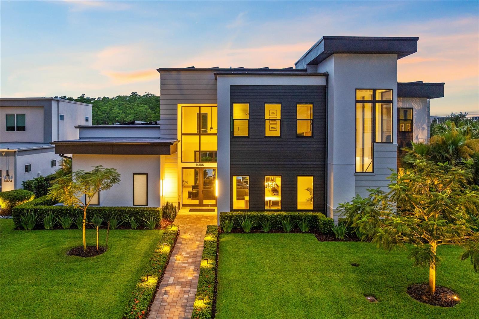 Step into a one-of-a-kind custom-built Envy Home on a 0.39-acre corner lot in Laureate Park. This 5-bedroom, 4 full bath, 2 half bath home blends luxury, functionality, and complete privacy with high-end upgrades throughout. Professionally landscaped with custom lighting, a double-wide aluminum gate, and fresh exterior paint (2024), the home offers striking curb appeal and smart design at every turn.
Inside, soaring ceilings, engineered hardwood floors, and expansive clerestory windows set the tone for a modern yet warm aesthetic. The spacious great room is anchored by an electric fireplace with a sleek tile feature wall and flows into a chef’s kitchen outfitted with custom flat-panel cabinetry, designer backsplash, stone countertops, a Sub-Zero built-in refrigerator, and an oversized quartz island with waterfall edges. A walk-in pantry adds functional storage.
The dining area features a custom floating credenza and oversized windows. Nearby, a temperature-controlled wine cellar adds a dramatic and upscale touch. The main level also includes a private office with large windows and glass French doors, a stylish powder bath, and a laundry room.
The first-floor primary suite offers direct pool access, motorized blackout shades, and a custom-designed walk-in closet. The en suite bath is a spa-like retreat with a freestanding soaking tub, dual vanities, a rain shower with multiple heads, and split vanities.
Upstairs, a generous loft features built-in shelving, a wet bar, and ample space for relaxing or entertaining. Three additional bedrooms include walk-in closets, with two enjoying private en suite baths. A second full laundry room adds convenience.
The outdoor living area is a true showpiece. A 45-ft saltwater pool and spa with a sun shelf, electric heater, blower, auto fill/drain, and adjacent cold plunge create a resort vibe. The pool is surrounded by marbled stone decking, tropical landscaping, and premium perimeter lighting. A hot/cold outdoor shower and full summer kitchen with built-in grill and refrigerator make entertaining easy. Motorized exterior shades, ceiling fans, and a fully screened lanai complete the space.
The oversized 3-car garage includes epoxy floors, built-in cabinetry, ceiling-mounted storage, and two 240V EV outlets. The home also features a 34MWh solar system, whole-house water softener and kitchen filtration system (2024), smart Control4 automation for music, TV, lighting, and security cameras, and custom motorized blinds throughout.
Laureate Park isn’t just a neighborhood—it’s a lifestyle. Dive into resort-style living with access to the Aquatic Center, LP Fit gym, scenic parks, and over 44 miles of trails. Ideally located in Lake Nona, you're just minutes from Medical City, the VA Hospital, Nemours, top dining, shopping, and the Lake Nona Town Center. Enjoy quick access to major highways, Orlando International Airport, the USTA National Campus, and world-renowned theme parks and beaches. This home offers the perfect blend of luxury, space, and community. Come experience elevated living—schedule your private tour today!
