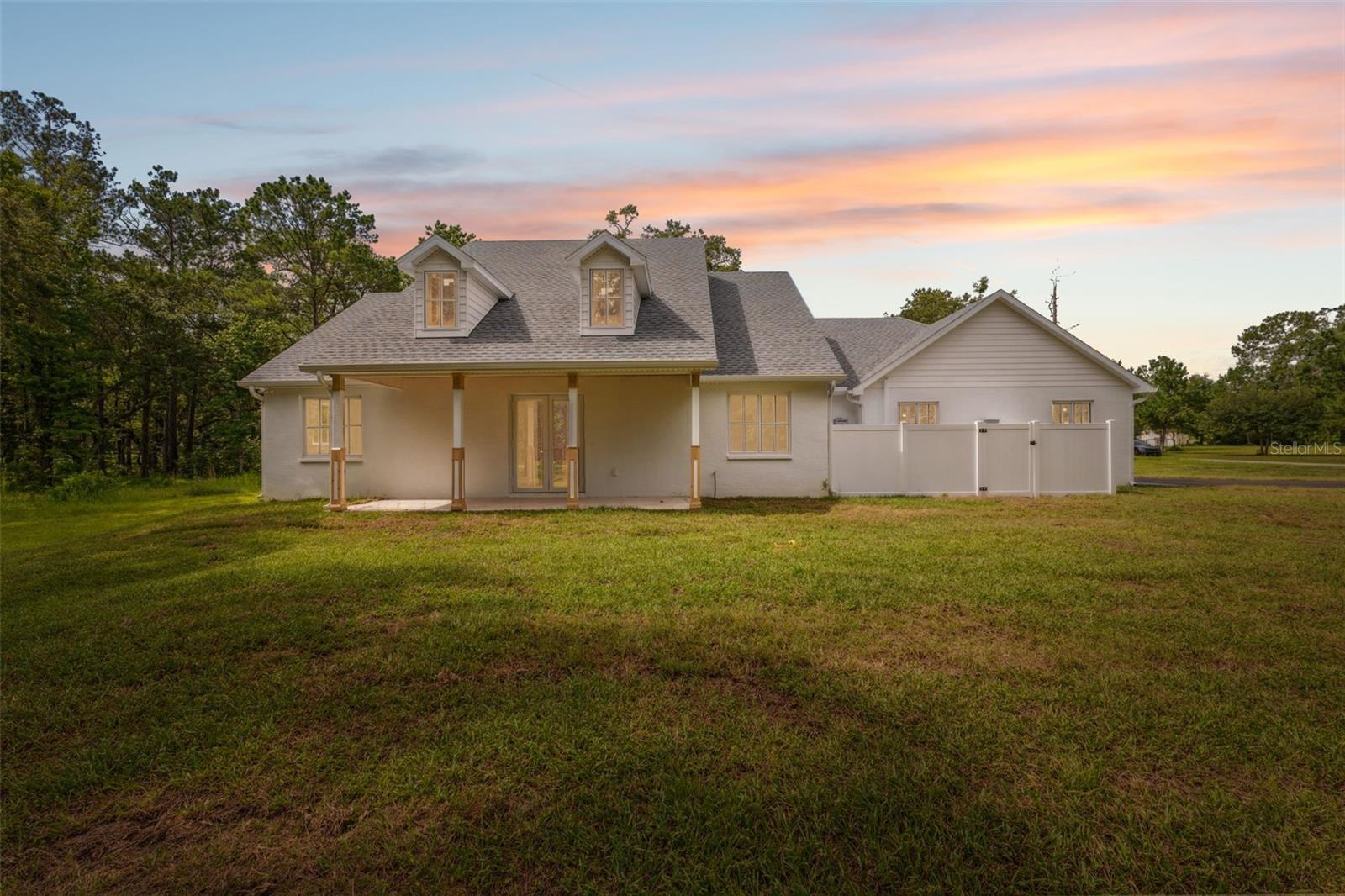 Brand-new custom farmhouse-style home on 2.3 acres in Brooksville. This property combines modern efficiency with classic design elements throughout. The open-concept layout includes 4 bedrooms, 2.5 baths, and a spacious living area featuring a wood-burning fireplace. The kitchen is equipped with an induction cooktop, double wall oven with microwave and air fryer, wine cooler, farm sink, dishwasher, and a large pantry with double doors.
Interior finishes include 40"x40" Italian ceramic tile flooring, all LED lighting, Icynene spray foam insulation, impact glass windows, and a smart HVAC system. The owner’s suite offers a stand-alone shower with rain and handheld fixtures, a clawfoot tub, dual vanities with backlit mirrors, a linear drain, and a private water closet. The second full bath includes a tub/shower combo with tile to the ceiling.
Additional features: tankless gas water heater, 200-amp service, impact-rated insulated garage door, epoxy garage floor, garage storage room, attic storage with plywood, whole-home generator hookup, gutters, front porch with tongue-and-groove ceiling, covered rear lanai, and a septic system with lift station. The laundry room includes a sink and pedestal washer/dryer. Seller is offering a $5,000 credit toward custom closet and pantry build-out.
