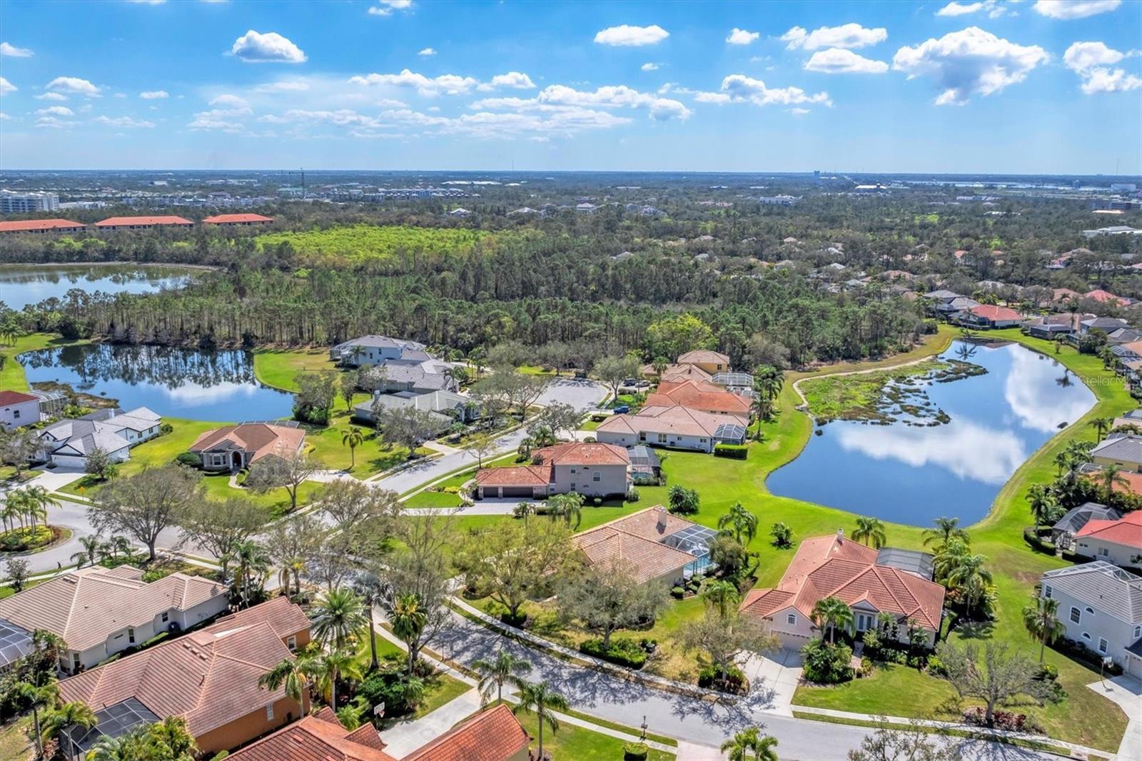 Located in the Heart of Lakewood Ranch, this 4-bedroom, 3-bath home with an office, 3-car garage, and a private pool and spa sits on an oversized lot with breathtaking lake views. The highly sought-after River Club community offers the perfect blend of tranquility and convenience, just a short walk to Lakewood Ranch Main Street’s dining and shopping and within easy reach of University Town Center, I-75, downtown Sarasota, downtown Bradenton, Sarasota Airport, and the stunning beaches of Siesta Key, Lido Key, Anna Maria Island, St Pete Beach, and Tampa. Inside, this thoughtfully designed home features a spacious fourth bedroom that can also function as a bonus room, a well appointed kitchen with wood cabinetry, stainless steel appliances, an island, a pantry, a breakfast bar, and a cozy dinette. The separate Living Room and Family Rooms provide the ideal space for both formal gatherings and casual entertaining. The luxurious Primary Suite boasts a spa-like en suite bathroom with dual vanities, a soaking tub, and a walk-in shower. Step outside to your private oasis, where the expansive screened lanai showcases a sparkling pool and spa, an outdoor kitchen, and stunning lake views, perfect for year round relaxation and entertaining. Recent updates include a new roof (2022), two brand new Lennox A/C (2024 and 2025) systems installed, an updated Pool surface, new Plantation Shutters throughout, and fresh landscape curbing. River Club is a golf course community with no CDD fees, optional membership, low HOA fees, and larger lot sizes. Plus, it is in walking distance to top-rated schools. Don’t miss this incredible opportunity to own a slice of paradise in one of Lakewood Ranch’s most coveted neighborhoods!