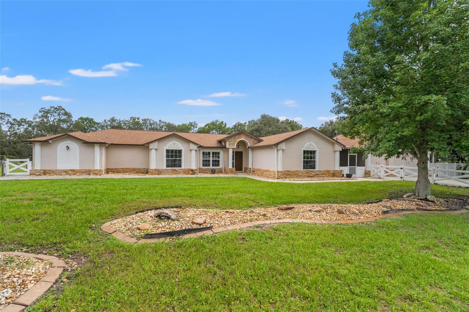 Welcome to this spacious 2,564 sq. ft. home in the highly desirable community of Oakwood Acres in gorgeous Brooksville, Florida! Nestled on a fully fenced oversized 2.5-acre lot, this property offers the perfect combination of space, functionality, and comfort. With 4 bedrooms, 3 full bathrooms, a large bonus/flex room, an attached 3-car garage, and an additional detached garage/workshop, there’s room for everything—whether it’s hobbies, storage, or extra vehicles. Inside, you’ll find a beautifully updated kitchen with shaker-style cabinetry, gleaming granite countertops, and an oversized island that opens to the family room—ideal for entertaining or casual family living. Additional cabinetry and counter space beneath the kitchen window add both charm and practical storage. The home’s split-bedroom floor plan provides privacy, while the cozy living area features a wood-burning fireplace that brings character and warmth. A standout feature of the home is the private in-law suite or second primary suite, designed with comfort and independence in mind. It offers its own private entrance via concrete sidewalks, making it easily accessible. The suite includes an oversized walk-in closet PLUS additional storage closets, an ensuite bathroom with a dual sink vanity, and a massive walk-in shower with an oversized bench seat—offering ADA accessibility and convenience. With its own dedicated thermostat, HVAC system, and water heater, this space is ideal for extended family, guests, or a private home office! Enjoy peaceful views from the screened rear lanai that overlooks the expansive backyard. There’s plenty of room for outdoor fun, gardening, pets, or a pool! And for peace of mind during Florida’s stormy season, this home is equipped with a Generac whole home generator, so you're never left in the dark. Located just minutes from the Suncoast Parkway, this home offers a prime location with easy access to Tampa International Airport, hospitals, restaurants, shopping, and entertainment. Here, you can have the best of both worlds... tranquility of country living with all the convenience of nearby amenities! Schedule your showing soon, and make this home yours!