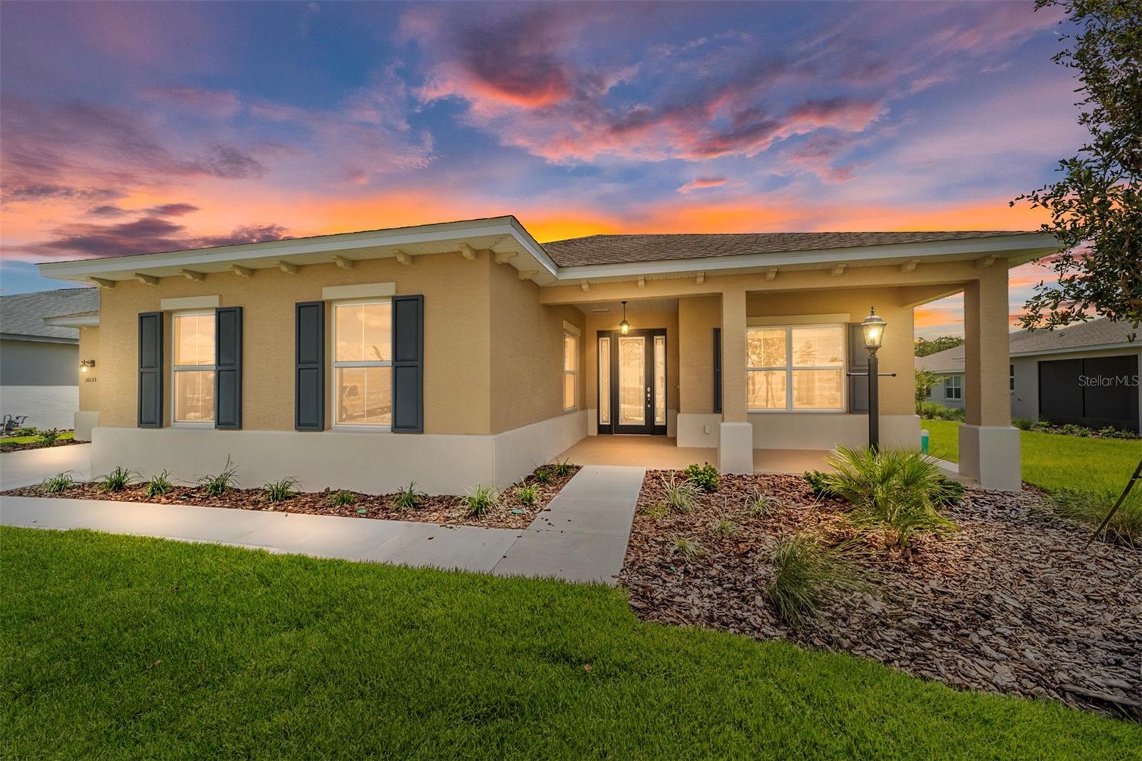 Welcome to the Magnolia Model, a beautifully designed new construction home located in the desirable LongLeaf Ridge neighborhood at On Top of the World, Ocala’s premier 55+ active adult community. This home offers 2 bedrooms, 2.5 bathrooms, a versatile flex room, an oversized 2-car garage, and a separate attached golf cart garage. Step inside to find tray ceilings, tile flooring throughout, and an open floor plan that perfectly combines style and functionality. At the front of the home, the flex room with French doors creates a private space for a home office or hobby room. The living area is light and bright, featuring a 4-panel sliding door that opens to the screened lanai, ideal for indoor-outdoor living. The dining space, highlighted by four floor-to-ceiling windows overlooking the backyard, creates a stunning backdrop for everyday meals and entertaining. The gourmet kitchen showcases quartz countertops, premium white staggered cabinetry with crown molding, under-cabinet lighting, stainless steel appliances, and a walk-in pantry—a perfect blend of beauty and convenience. The primary suite is a spacious retreat with a tray ceiling, a large 3-panel window with blinds, and a huge walk-in closet. The spa-inspired en suite features a double vanity with quartz counters and a zero-entry tiled shower with built-in bench and glass enclosure, offering both accessibility and luxury. With its elegant finishes, thoughtful layout, and outstanding community amenities, this Magnolia model is designed for both comfort and style. Don’t miss your opportunity to own a brand-new home in On Top of the World—schedule your private showing today!