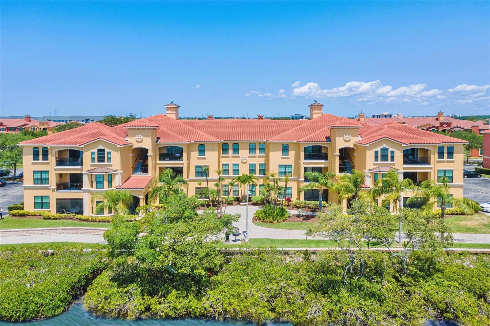 Welcome to your waterfront retreat at The Grand Venezia!
Discover the perfect blend of comfort and sophistication in this 3rd-floor condominium on the beautiful shores of Tampa Bay. Situated in an exclusive gated community, this spacious 2-bedroom, 2-bath residence has been carefully maintained and thoughtfully updated. Step inside and you’ll find an open-concept layout with neutral tile flooring extending through the kitchen, dining area, and living room. Both bedrooms showcase updated wood-look laminate floors, adding warmth and style. The kitchen is designed for both cooking and entertaining, featuring granite countertops, a breakfast/entertainment bar, and stainless steel appliances that flow seamlessly into the dining area. The home’s 9-foot ceilings, enhanced with crown molding in the main living spaces and primary suite, create an airy and elegant atmosphere. A generous laundry room includes a full-sized washer and dryer for added convenience.
Life at The Grand Venezia means resort-inspired living every day. Residents enjoy a geothermal-heated pool and spa, sauna, fitness center open around the clock, and lighted courts for tennis and pickleball. There’s also a playground, a complimentary car wash station, and a scenic 1.5-mile illuminated waterfront promenade ideal for morning jogs or evening strolls. With a 24-hour staffed guard pavilion, peace of mind is always included. Don’t miss your chance to own a slice of paradise.