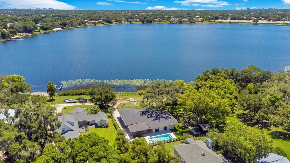 Stunning newer LAKEFRONT construction in the heart of Downtown Windermere completed in July 2024. This exquisite single-story home spans 2,868 sq ft with an open-concept design, featuring white oak hardwood floors and contemporary style throughout. Highlights include 4 bedrooms, each with its own en-suite bathroom, living room with expansive lake views, European-style kitchen, home office, and laundry room. Indulge in top-tier amenities including a luxury heated pool and spa, quartz countertops and smart appliances. Enjoy cool lake breezes and sunrises from your front porch overlooking the lake and finished in Nordic travertine. Located on the highly desirable Lake Bessie, famed for its boating and fishing, the property has 100’ of lakefront with the option to build your own private dock. Downtown Windermere is just a short walk or golf cart ride away - enjoy the weekly farmers market, tennis courts, brewery, restaurants and parks this charming town has to offer. This home offers the ultimate in contemporary lakefront living at an unbeatable price. Don’t miss your chance!