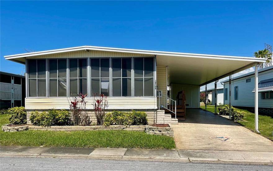 Priced to sell! This 2-bedroom, 2-bath double-wide manufactured home in Blue Jay Estates is located in a friendly and active 55+ community where you own the land. This property is situated in a non-flood zone and features low monthly maintenance fees of $230, which include water, sewer, trash, lawn care, and more. The home offers a functional layout with newer windows in the living area and a nicely designed kitchen featuring ample cabinetry, generous counter space, a pantry closet, and a large sink positioned beneath a window for natural light. The dining room includes a built-in buffet with a lovely stained-glass accent. Ceiling vents are located overhead, helping provide comfortable airflow throughout the home. The spacious Florida room adds approximately 200 square feet of additional living space and features vinyl windows, a decorative brick accent wall, portable A/C, and a ceiling fan. Both the primary bedroom and the second bedroom feature spacious walk-in closets and both bathrooms are equipped with grab bars providing added safety and accessibility. Outside, the property offers attractive landscaping and a long driveway with a custom ramp for easy access. A storage shed houses the washer and dryer and provides additional storage space and a workbench. This home is full of potential and just needs a little TLC to shine. Blue Jay Estates offers an active lifestyle with a heated community pool, shuffleboard and bocce courts, and a vibrant social club with many activities. There is also a designated area where residents may park a boat or RV at no additional fee when space is available. Conveniently located near beaches, the Pinellas Trail, parks, shopping, medical centers, and airports.