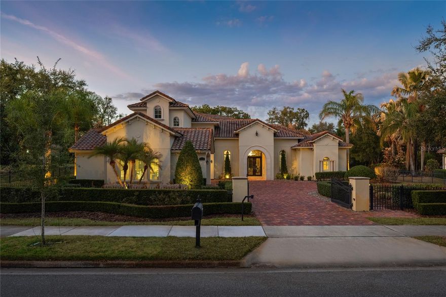 Set within the quiet, gated enclave of Braemar in Gotha, 9729 Lake Hugh Drive is the kind of estate that rarely comes to market. Positioned on nearly an acre, the property feels private and expansive from the moment you arrive, with mature landscaping, a stately presence, and over 6,000 square feet of thoughtfully curated living space. Inside, the home balances scale with warmth. Soaring ceilings, rich architectural detailing, and expansive windows create rooms that feel both grand and inviting. The primary suite is a retreat in every sense, complete with its own sitting area and French doors that open directly to the pool terrace. It is a space designed for slow mornings and quiet evenings, tucked away from the rest of the home for complete privacy. The floor plan unfolds with intention. Secondary bedrooms are generously sized and well separated, offering comfort for family and guests alike. A dedicated office provides a refined work-from-home setting, while multiple living areas invite connection, conversation, and relaxation. At the heart of the home, the kitchen is built for both performance and presentation. Outfitted with a gas range, premium appliances, custom cabinetry, and a substantial center island, it opens seamlessly to the main living spaces. Whether hosting an intimate dinner or a larger gathering, the layout supports effortless entertaining.
Entertainment continues throughout the residence. A fully equipped home theater delivers a cinematic experience, while game rooms on both levels create space for recreation without disrupting the main living areas. Every detail has been considered to make everyday living feel elevated. The outdoor living experience rivals that of a private resort. A custom pool and spa anchor the backyard, complete with specialty lighting and water features. An outdoor kitchen and dining area set the stage for evenings under the stars, complemented by a fire pit and even a private putting green. The grounds feel curated yet relaxed, designed for both celebration and quiet escape. Modern systems enhance comfort and convenience, including integrated music and communication technology and a comprehensive security setup. A four-car garage provides ample space for vehicles, storage, and hobbies. This is more than a home. It is a private estate that delivers scale, sophistication, and lifestyle in one of Gotha’s most desirable communities. 9729 Lake Hugh Drive offers the rare opportunity to own a property that truly lives as beautifully as it looks.