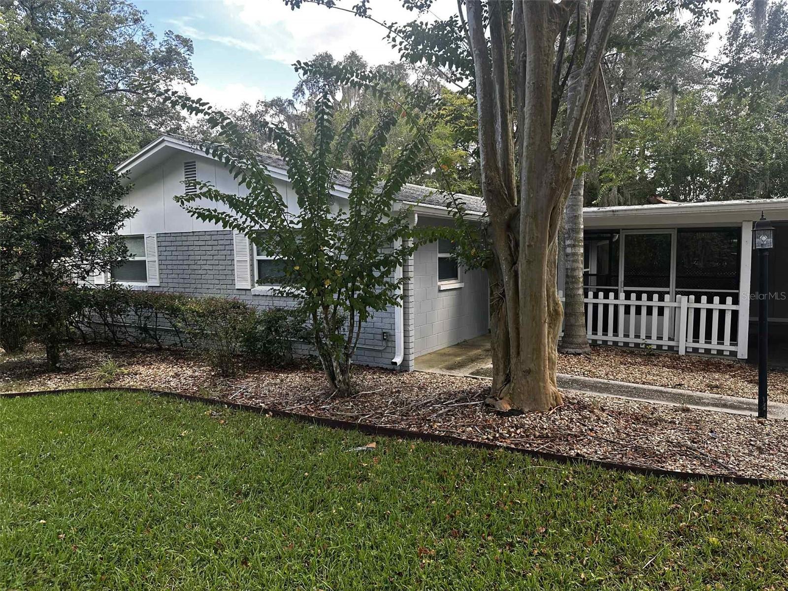 ** Private Paradise in a Prime Location
Welcome to your own secluded sanctuary, nestled in the heart of The Ocala Highlands neighborhood—where peaceful privacy meets everyday convenience.
Tucked away on a beautifully landscaped lot, this charming home is surrounded by mature trees and lush greenery, offering the perfect retreat from the hustle and bustle—yet just minutes from the public library, grocery stores, emergency rooms, and local restaurants.
Step outside to enjoy nearly 300 square feet of screened lanai space, ideal for relaxing with a good book or entertaining guests in the shade. A concrete pad with water and electric hookups sits beside the carport—perfect for your RV or extra parking—while a large gate provides easy access to the fenced backyard oasis.
Inside, the cozy kitchen is equipped with a refrigerator, cooktop, oven, dishwasher, and a generous pantry—easily convertible to a laundry area if desired. The two bathrooms offer flexibility, with one featuring a shower/tub combo and the other a walk-in shower. The bedrooms are nicely sized, complemented by extra hallway storage and closets throughout.
At the head of the carport, you’ll find a versatile bonus room with A/C—perfect for a home office, craft room, or laundry setup.