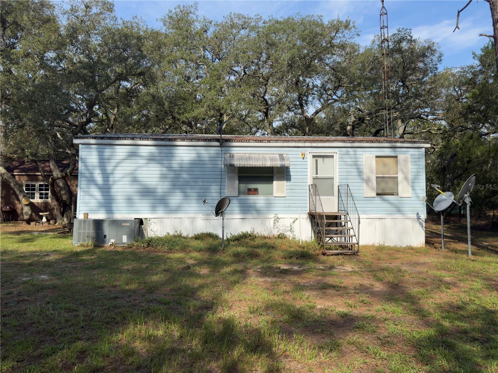 1996 double-wide manufactured home on just over an acre in Dunnellon. This 3 bedroom, 2 bathroom home features a split floor plan. The property includes a mix of cleared land and wooded area for privacy, with access from a paved road. The home is move-in ready but will need updating and some restoration. A relatively new permitted shed was installed a few years ago, offering additional storage. Great opportunity to customize and add value.