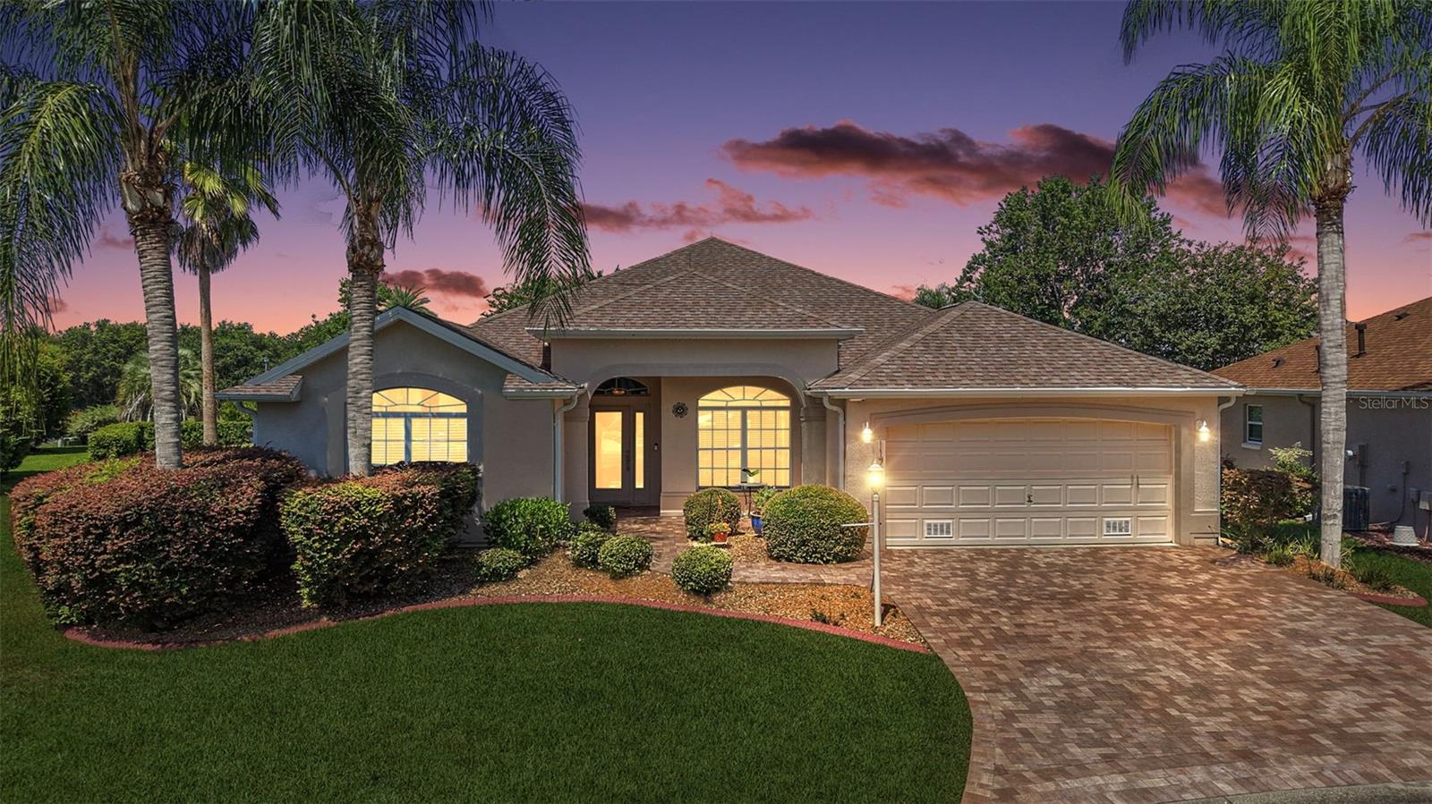 GORGEOUS, 3/2 BLOCK and STUCCO Gardenia featuring a FABULOUS ENCLOSED LANAI with EXTENDED PAVER PATIO and PRIVACY LANDSCAPING quietly nestled on an OVERSIZED CUL-DE-SAC lot with ROOM FOR A POOL in the highly sought after village of Sunset Pointe! - JUST MINUTES to Lake Sumter Landing Town Square and Lake Miona Regional Recreation Center! BOND PAID! The EXQUISITE exterior of this lovely home boasts PAVER drive and walk ways and MATURE TROPICAL landscaping with CURBED beds. A MODERN LEADED GLASS door with an arched transom window welcomes you into the GENEROUS foyer. The OPEN CONCEPT floor plan and soaring VAULTED ceilings in the living and dining areas create a bright, spacious atmosphere. Wood-grain LUXURY VINYL PLANK flooring flows throughout these rooms, while elegant columns add a refined touch to the formal dining room. The MAGNIFICENT kitchen is a chef's delight showcasing WHITE cabinetry, GRANITE countertops, STAINLESS STEEL appliances, built-in PANTRY, EAT-IN breakfast bar, and TILE flooring. It’s adjacent dinette offers a casual eating space with double windows and a large arched transom. From the main living area, a DOUBLE set of sliding glass doors invite you into the FABULOUS ENCLOSED LANAI offering 330sf of ADDITIONAL LIVING AREA and a PLETHORA of FULL GLASS fixed panel windows for an ABUNDANCE of NATURAL LIGHT. Surrounded by MATURE PRIVACY LANDSCAPING, this SPACIOUS RETREAT is perfect for RELAXING with your morning coffee or ENTERTAINING friends and family! An exterior French door opens to the adjacent PAVER PATIO - ideal for grilling or simply enjoying the beautiful Florida sun! Back inside, retreat to your luxurious primary bedroom, boasting HIGH VAULTED ceilings, LVP flooring, TWO WALK-IN closets, and sliding glass doors to the LANAI. It’s ensuite bathroom features WHITE cabinetry, DOUBLE sinks, MAKE-UP vanity, GLASS-ENCLOSED WALK-IN shower with TILE finishes, separate water closet, and a LARGE LINEN closet. A SPLIT FLOOR PLAN, places two additional bedrooms and second bathroom near the front of the house, creating a PRIVATE GUEST WING or QUIET home office area. Bedroom two offers a built-in closet and convenient entertainment niche with white cabinetry. The second bathroom features TILE floors, WHITE vanity, TILED tub and shower combination, and a hallway LINEN closet. The third bedroom has a built-in closet and DOUBLE windows with an arched sunburst transom window. A centrally located INTERIOR LAUNDRY ROOM offers WHITE cabinets and shelving with TILE floors. It leads you into the two-car garage with attic access stairs, and SUSPENDED OVERHEAD SHELVING for AMPLE STORAGE! The Village of Sunset Pointe offers an UNBEATABLE LOCATION - ONLY MINUTES from Lake Sumter Landing - where you’ll find an array of shopping, dining, and nightly entertainment! The nearby Lake Miona Regional Recreation Center offering a sports pool, exercise facility, and so much more! Health enthusiasts will love the outdoor exercise area and Black Lake Walking Path that meanders along the preserve and through the majestic oaks. Enjoy Heron and Pelican executive golf courses, Cane Garden Country Club’s 27-hole championship course, and multiple recreation centers offering pools, pickle ball, and an abundance of activities! DON’T MISS YOUR OPPORTUNITY to make this AMAZING HOME in an UNBEATABLE LOCATION YOUR OWN! PLEASE WATCH OUR WALKTHROUGH VIDEO and CALL TODAY for your private showing or virtual tour!