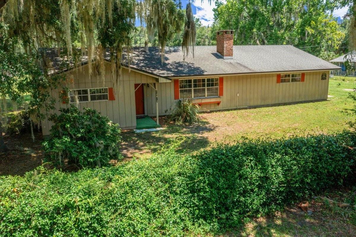 This adorable home has so much to provide with 2 En-Suite Bedrooms, 2 1/2 baths 2 car garage, Carport with shed on 1 ACRE within 3 minutes to the boat ramp for Orange Lake! As you enter, the warm and cozy sunken living room welcomes you, with a rock fireplace & room for relaxing. Off the hallway is one of the owners' suites with walk in closet, en suite bathroom with tub/shower combo. The other bedroom offers 2 walk-in closets, en-suite bathroom with tub/shower combo. As you enter the kitchen you have ample counter space with cabinets for storage, gas stove top, double stack ovens with the sink overlooking the acre yard. Off the kitchen is a screen porch. Inside laundry room offers some additional storage and a 1/2 bath. The dining area offers a sliding glass door with a porch for enjoying the evenings. Additional features include a storage shed, 20X30 Carport, chicken coop, mature fruit trees, most of the yard fenced with a double gate, water softener, close to the boat ramp, walking distance to the Yearling restaurant.