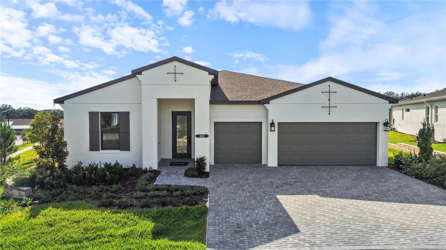 One or more photo(s) has been virtually staged. This move-in ready Pearl floorplan located within Cresswind Hammock Oaks in Lady Lake, Florida offers 3 bedrooms, 3 full baths, a flex room, an extended owner’s suite, and a spacious 3-car garage, all positioned on a premium corner homesite with enhanced landscaping. Designed for both everyday comfort and entertaining, the open-concept layout connects the great room, dining area, and chef-inspired kitchen while a 16-foot sliding glass door creates a seamless transition to the extended covered lanai with privacy wall and future summer kitchen rough-ins. The kitchen is thoughtfully appointed with Monogram appliances, a 36” cooktop, designer hood, waterfall-edge quartz island, artisan backsplash, soft-close cabinetry, and oversized pot-and-pan drawers. Large-format 32x32 polished tile flooring extends throughout the main living areas, foyer, flex space, kitchen, and baths, creating a clean and cohesive design aesthetic. Privately located at the rear of the home, the extended owner’s suite offers additional living space and features a spa-style bath with an oversized frameless shower, tile extended to the ceiling, quartz countertops, ceiling-height mirrors, and designer finishes throughout. Secondary bedrooms are positioned separately for guest privacy, each with access to a full bath. Additional highlights include upgraded interior doors and trim, a designer glass front entry door, spray foam insulation, upgraded carpet padding in bedrooms, enhanced lighting packages, bronze exterior window detailing, and a WiFi-enabled garage door opener. Located within the gated 55+ community of Cresswind Hammock Oaks, residents enjoy access to resort-style amenities, fitness offerings, pickleball, social clubs, and a nationally recognized active adult lifestyle program. See Community Home Guides for details.