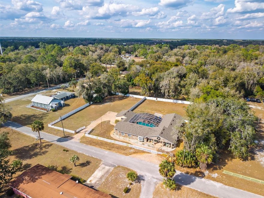 Assumable mortgage is available for this stunning residence in a highly desirable, well-established neighborhood, offering luxury upgrades, accessibility, and resort-style outdoor living. This magnificent 3 bedrooms, 2 baths, 3,500 sq ft residence sits on an extra-large, fully fenced lot with everything thoughtfully designed on one level for easy, comfortable living. Recent upgrades include a new roof installed last year, new central air conditioning, a new gas tankless hot water heater completed in 2025. The interior shines with real wood floors throughout, crown molding, upgraded baseboards, and extra-wide doors with smooth wood-to-tile transitions—designed for comfortable accessibility and barrier-free movement for persons with disabilities. The grand master suite features a spacious walk-in closet (newly customized in 2025) and a luxurious master bath with an upgraded shower package, including a large frameless open glass shower and premium finishes. Additional living spaces include a formal living area with fireplace, formal dining area, spacious family room, casual dining nook, and wet bar. The custom kitchen offers an open concept with timeless cherry wood cabinetry matched throughout the home, abundant storage, contrasting dark granite countertops on the bar and island, a large standalone island, and a breakfast area that overlooks the backyard. Step outside to your private resort-style oasis: a huge sparkling pool surrounded by an expansive paved deck—perfect for entertaining and enjoying Florida's long, sunny months. Perfection, value, and location all in one—this sought-after area is poised for growth with schools, shopping, dining, and much more nearby. Schedule your private showing today!