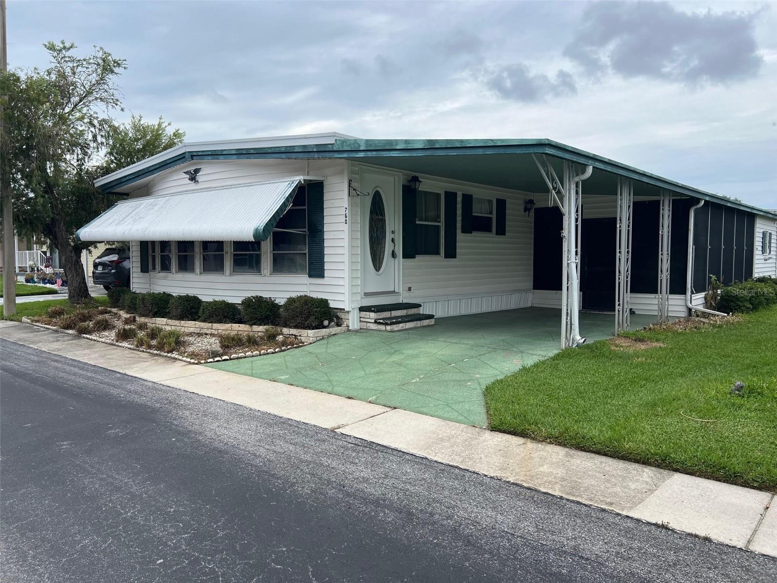 Palm Hill Country Club, a five-star mobile home park, is the community chosen time after time to be a permanent or seasonal residence for the 55 and over population. The reason this park is picked to be home by so many is its location within the Tampa Bay area, as well as it's extensive amenities like golf, swimming pools and jacuzzis, tennis courts, bocce courts, shuffleboard courts, billiards rooms, horseshoes and pickleball court. As if this isn't enough, for a monthly $554.00 maintenance fee, you will be provided water, sewer, garbage, lawn care, cable and internet. This recently listed 2-bedroom, 2 bathroom,1296 sq ft property is just the way to be introduced to such an exceptional area!
INTERIOR:
Looking for a blank slate? This could be the one! In this spacious, fully furnished residence you will discover an expansive floor plan that integrates vinyl and carpet flooring, while updated windows ensure ample natural light throughout the home. Central heating and air (2020), ceiling fans, and ceiling ducts provide consistent climate control year-round. The kitchen is equipped with major appliances, including a dishwasher and disposal, and connects to a designated dining area and open living space. The primary bedroom offers generous proportions, two closets, and a private ensuite featuring a walk-in shower. A well-sized guest bedroom is complemented by an adjacent bathroom with a shower/tub combination and a long vanity offering additional storage.
EXTERIOR:
Simple, straightforward, and ready for your ideas would be the way to describe the exterior of this home. Vinyl siding and awnings provide shade, while the lowered Florida room creates a relaxed space perfect for indoor/outdoor living or entertaining friends and family. A roof-over is currently in place but will need replacement—something to consider as you make it your own. You'll find a shed that houses the washer and dryer, adding extra utility to this easygoing setup. Priced accordingly at $75,000, including a share, allows for a solid start in a great community. Here’s a place with potential—and a price to match!
