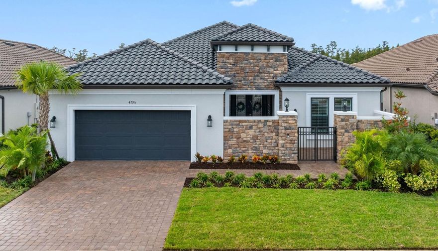 Embrace the luxury of resort-style living in this Taylor Morrison-built Pallazio model located in the gated 55+ community of Esplanade at Wiregrass Ranch. This Mediterranean-inspired home offers 3 bedrooms, 3 bathrooms, and 3,087 square feet of beautifully designed living space. From the moment you enter through the courtyard’s wrought-iron gate and the striking glass double front doors, you’ll be greeted by elegance and attention to detail throughout. Inside, crown molding, 8-foot doors, and tile flooring flow seamlessly across the open-concept layout. The great room features a custom media wall with TV mount and electric fireplace, creating a warm and inviting atmosphere. Electric blinds on the sliding glass doors open to the extended covered patio, offering panoramic screening, ceramic tile flooring, and pre-plumbing for an outdoor kitchen—ideal for entertaining or relaxing outdoors. The gourmet kitchen is a chef’s dream, showcasing top-of-the-line cabinetry, quartz countertops, stainless steel appliances, and a gas cooktop with stainless vent hood. A spacious island with pendant lighting opens to the great room and dining area, perfect for gatherings. The primary suite serves as a private retreat with tray ceilings, a custom closet system, and a spa-inspired bath featuring an oversized glass-enclosed shower and dual vanities. The flex room off the foyer is ideal for an office or reading area. Two guest bedrooms are thoughtfully positioned on opposite sides of the home—one with private bath access and the other an ensuite. All bathrooms continue the luxurious theme with matching quartz surfaces and upscale finishes. Additional highlights include plantation shutters, a large laundry room with built-in cabinets and sink, and a two-car garage. Paver driveway and walkway, paired with lush landscaping, enhance the home’s pristine curb appeal. Residents of Esplanade at Wiregrass Ranch enjoy an exceptional 55+ lifestyle with resort-style amenities, wellness programs, and endless opportunities for recreation and connection. Live every day to the fullest in a community designed to invigorate the mind, body, and spirit.