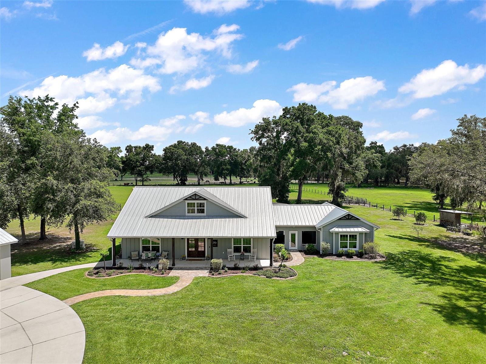 Welcome to your dream homestead where luxury meets laid-back country living. Nestled on 12 private, picturesque acres, this exceptional property offers everything you need to embrace a slower, more intentional lifestyle. The beautifully designed main home features 4 spacious bedrooms, 2.5 baths, and a versatile den/office space perfect for a future game room or home theater. A unique breezeway-style layout separates the main living quarters from two additional bedrooms, connected by a charming screened-in patio that leads directly to the home’s stunning saltwater pool. Fully enclosed and easily accessed from the central porch area, this backyard retreat is perfect for cooling off, entertaining, or simply enjoying peaceful evenings under the stars. Need space for guests, multi-generational living, or rental income potential? The detached garage offers two full parking spaces and includes a fully equipped in-law suite/apartment perfect for extended family or visitors. Additionally, a separate building features a two-car carport and an enclosed, air-conditioned garage space ideal for a home gym, workshop, or storing your classic car. Equipped with a whole-home Generac generator, this home is ready for anything. Outside, the property offers open pastureland for cattle or horses, a chicken coop for fresh eggs daily, and a small pond for peaceful views or future
fishing fun. Whether you’re looking to homestead, raise animals, or simply escape the hustle and bustle, this serene, self-sufficient oasis has it all. Come experience the beauty of country living without sacrificing comfort or convenience.