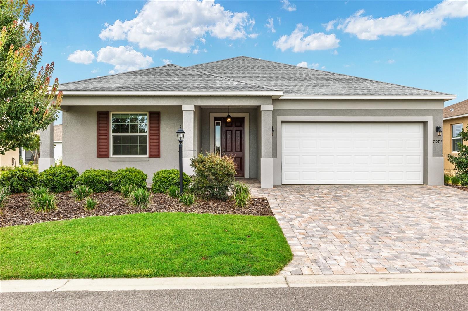 One or more photo(s) has been virtually staged. Welcome to this stunning 2021 Ginger model located the 55+ active adult community of Weybourne Landing. Featuring 2 bedrooms, 2 bathrooms, and a versatile flex room with French doors- perfect for an office, den, or hobby space-this home is thoughtfully designed for both comfort and style. Inside, luxury vinyl plank flows through the main living areas, while both bedrooms feature neutral carpet. The kitchen is a true highlight, offering a large center island overlooking the great room, perfect for casual meals or entertaining. Rich wood cabinetry is paired with upgraded granite countertops and stainless-steel appliances, and a separate counter space provides the ideal space for a coffee station or bar setup. The spacious primary suite includes a walk-in closet as well as a beautifully appointed ensuite bath with dual quartz vanities, upgraded tile shower, and a linen closet. Throughout the home, tastefully chosen neutral paint tones create a cohesive, upscale atmosphere. The home's curb appeal shines with beautifully landscape beds. Enjoy a fantastic front porch view overlooking a dry retention pond for great sunsets. This home is on a premium lot with a 15-foot easement between your side neighbor and a deep backyard that can easily accommodate a fenced yard as well as a swimming pool. Enjoy the convenience of curbside mail and trash service, and a location just moments from the community’s fitness center and pool. Weybourne is part of the On Top of the World campus and features golf cart access to shopping, restaurants, entertainment, health, and beauty.