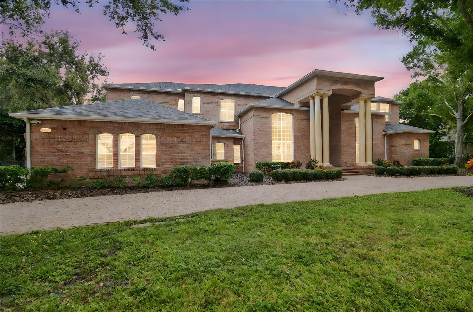 Welcome to this an exquisite one of a kind custom-built brick estate that embodies refined luxury and sophistication. This house is perfectly situated on a double lot of 1.5 acres in one of Tarpon Springs’ most sought-after luxurious neighborhoods. This magnificent home offers both privacy & grandeur, minutes from Gulf beaches, charming downtown shops, and top-rated schools. All with Brand New Roof & 3 newer HVAC systems.
As you drive up the circular paved driveway & enter through the double entry doors, you’re greeted by a breathtaking two-story foyer that opens to a formal living room with a circular staircase, soaring ceilings and sweeping views of the estate grounds.  Stunning gold-plated crystal chandeliers and a custom-made bookcase, serve as the centerpieces of the formal living room adding a touch of timeless elegance.  On the right, an executive office/ library with exquisite built in cabinetry overlooks the front yard, offers a peaceful retreat or quiet place to work. Every detail of this home reflects exceptional craftsmanship—from the rich millwork & triple crown moldings to the hand-finished cabinetry & architectural detailing throughout.
The chef’s kitchen is a masterpiece, featuring a large crystallite granite island, custom wood cabinetry, and premium stainless-steel appliances. A walk in pantry for storage. Across from kitchen, there is a stately formal dining room framed with Roman columns sets the stage for elegant dinner parties.
The home’s interior showcases marble, tile and rich hardwood flooring, complemented by arched doorways, art niches, and designer lighting. The two-story family room impresses with a built-in entertainment center, a fireplace and grand windows that fill the space with natural light. 
Each bedroom suite is generous in size including a walk-in closet, offering comfort and privacy for family and guests. Two bedrooms with ensuite bathrooms are located on the first floor, one on each side of the house.  There is also a guest half bathroom on the first floor.  The master primary suite is on the second floor, featuring its own fireplace, a spa-like marble bathroom, column surrounded garden tub, a walk in granite shower,  and two walk in closets.  The split plan offers two more bedrooms and a full bathroom on the other side of the second floor.  A second staircase, a small loft and a huge balcony overlooking the backyard allow for enjoyable views. 
Step outside to your private backyard oasis—complete with a sparkling pool and spa, paved travertine deck, surrounded by lush landscaping and calm pond, perfect for entertaining or unwinding in style.  Pool has a separate full bathroom that was recently remodeled.  A three-car side-entry garage and large side driveway, and side fenced yards for pets complete this extraordinary property.
This residence is part of a large gated community with security guards. Community features a clubhouse, golf course, and a private restaurant.  Location is key as it is a short drive to many florida beaches, Tarpon Springs sponge dock, many marinas, and about 30 minutes away from Tampa Internation Airport and St. Petersburg airport.  The community is surrounded by many shopping centers, county parks and close to major roads and highways which makes it the perfect location in the midst of everything.  
Experience the perfect blend of elegance, comfort, and timeless design in this remarkable Tarpon Springs estate.