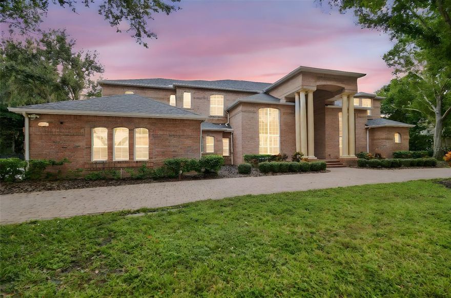 Welcome to this an exquisite one of a kind custom-built brick estate that embodies refined luxury and sophistication. This house is perfectly situated on a double lot of 1.5 acres in one of Tarpon Springs’ most sought-after luxurious neighborhoods. This magnificent home offers both privacy & grandeur, minutes from Gulf beaches, charming downtown shops, and top-rated schools. All with Brand New Roof & 3 newer HVAC systems.
As you drive up the circular paved driveway & enter through the double entry doors, you’re greeted by a breathtaking two-story foyer that opens to a formal living room with a circular staircase, soaring ceilings and sweeping views of the estate grounds.  Stunning gold-plated crystal chandeliers and a custom-made bookcase, serve as the centerpieces of the formal living room adding a touch of timeless elegance.  On the right, an executive office/ library with exquisite built in cabinetry overlooks the front yard, offers a peaceful retreat or quiet place to work. Every detail of this home reflects exceptional craftsmanship—from the rich millwork & triple crown moldings to the hand-finished cabinetry & architectural detailing throughout.
The chef’s kitchen is a masterpiece, featuring a large crystallite granite island, custom wood cabinetry, and premium stainless-steel appliances. A walk in pantry for storage. Across from kitchen, there is a stately formal dining room framed with Roman columns sets the stage for elegant dinner parties.
The home’s interior showcases marble, tile and rich hardwood flooring, complemented by arched doorways, art niches, and designer lighting. The two-story family room impresses with a built-in entertainment center, a fireplace and grand windows that fill the space with natural light. 
Each bedroom suite is generous in size including a walk-in closet, offering comfort and privacy for family and guests. Two bedrooms with ensuite bathrooms are located on the first floor, one on each side of the house.  There is also a guest half bathroom on the first floor.  The master primary suite is on the second floor, featuring its own fireplace, a spa-like marble bathroom, column surrounded garden tub, a walk in granite shower,  and two walk in closets.  The split plan offers two more bedrooms and a full bathroom on the other side of the second floor.  A second staircase, a small loft and a huge balcony overlooking the backyard allow for enjoyable views. 
Step outside to your private backyard oasis—complete with a sparkling pool and spa, paved travertine deck, surrounded by lush landscaping and calm pond, perfect for entertaining or unwinding in style.  Pool has a separate full bathroom that was recently remodeled.  A three-car side-entry garage and large side driveway, and side fenced yards for pets complete this extraordinary property.
This residence is part of a large gated community with security guards. Community features a clubhouse, golf course, and a private restaurant.  Location is key as it is a short drive to many florida beaches, Tarpon Springs sponge dock, many marinas, and about 30 minutes away from Tampa Internation Airport and St. Petersburg airport.  The community is surrounded by many shopping centers, county parks and close to major roads and highways which makes it the perfect location in the midst of everything.  
Experience the perfect blend of elegance, comfort, and timeless design in this remarkable Tarpon Springs estate.