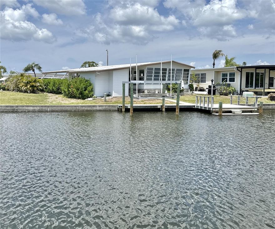 One or more photo(s) has been virtually staged. AFFORDABLE WATERFRONT! Just move-in to this 3 bed/2 bath remodeled home located on navigable saltwater canals to Tampa Bay with no bridges. Property is a BOATER'S PARADISE with 15' x 12' private composite dock with 20' walkway, fish cleaning station and 7,000 pd boatlift with water and electric. Large 120 sq. ft shed holds boating equipment or use as storage. Extra bonus is the concrete seawall that is maintained by the Co-op! REMODELED home is move-in ready and doesn't disappoint. Open floor plan with large living/dining/kitchen area that opens to 200 sq. ft Florida room with expansive views of the water. Entertaining friends and family has never been so relaxing. Kitchen has modern white appliances and large island with lots of cabinet space. With three comfortable bedrooms including a primary bedroom ensuite with walk-in closet, guest bedroom with wall of closets and third bedroom that could be an office/den/hobby room, you'll have plenty of space for privacy and storage. Two luxury bathrooms with easy use walk-in showers, decorative tile and beautiful vanities are perfect after a day of boating fun. This home has been LOVINGLY MAINTAINED and it shows:  2024 luxury vinyl plank flooring throughout, 2024 HVAC system, newer double paned windows, 2018 roof, 2025 washer and dryer, fully transferrable termite and pest policy, and transferable flood policy. NO FLOODING in 2024 storms! Two pets (dogs or cats) up to 35 pds each are welcomed. Use property as a full-time residence, winter retreat or investment property as renting is allowed with 2-month minimum. Location within the community is excellent as it's on a beautiful inlet creating a quiet tranquil setting. Property is located in popular gated Americana Cove that is only 10 mins from downtown St. Petersburg, 20 mins to downtown Tampa and two airports and 25 mins to beaches. Minutes away is 4th street dining/shopping and grocery. Low monthly maintenance fee of $410 includes water, sewer, trash pick up, lawn mowing, 24 hr manned gate, private streets and all amenities including clubhouse, heated pool, fitness center, bocce, two private boat ramps and kayak launch and so much more! Finding waterfront property in St Petersburg for this low price doesn't happen often. If you've been pricing waterfront property, you'll know what a find this is!