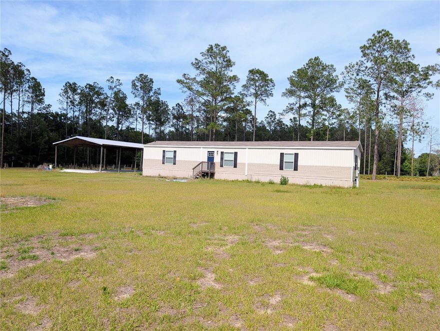 It's hard to beat the location of this attractive fenced and gated 5 acres near High Springs. The drive to it from the town (3.5 mi) is one of the most scenic in the area, a paved live oak-lined shaded avenue. The manufactured home was built in 2022 and has three bedrooms (split plan), two full baths, a laundry/utility area, and an open entry area with the kitchen and living room combined. Of considerable value is the 40' x 60' huge pole barn on a thick concrete pad. The parcel is split into a front and a back section of about the same acreage, defined by a central dividing fence behine the home and pole barn. The parcel is perimeter wire fenced and has black board fencing along the street with a recessed electric entry gate. From this home, one can take a variety of routes for access to Newberry, Alachua, and Gainesville, while remaining in the countryside avoiding more congested highways. The distance to I-75 exit #399 (High Spgs/Alachua) is 6.5 miles from this home. At that exit are Publix, Santa Fe High School, and a variety of restaurants and service businesses. There is no HOA. It's zoned A-agriculture.