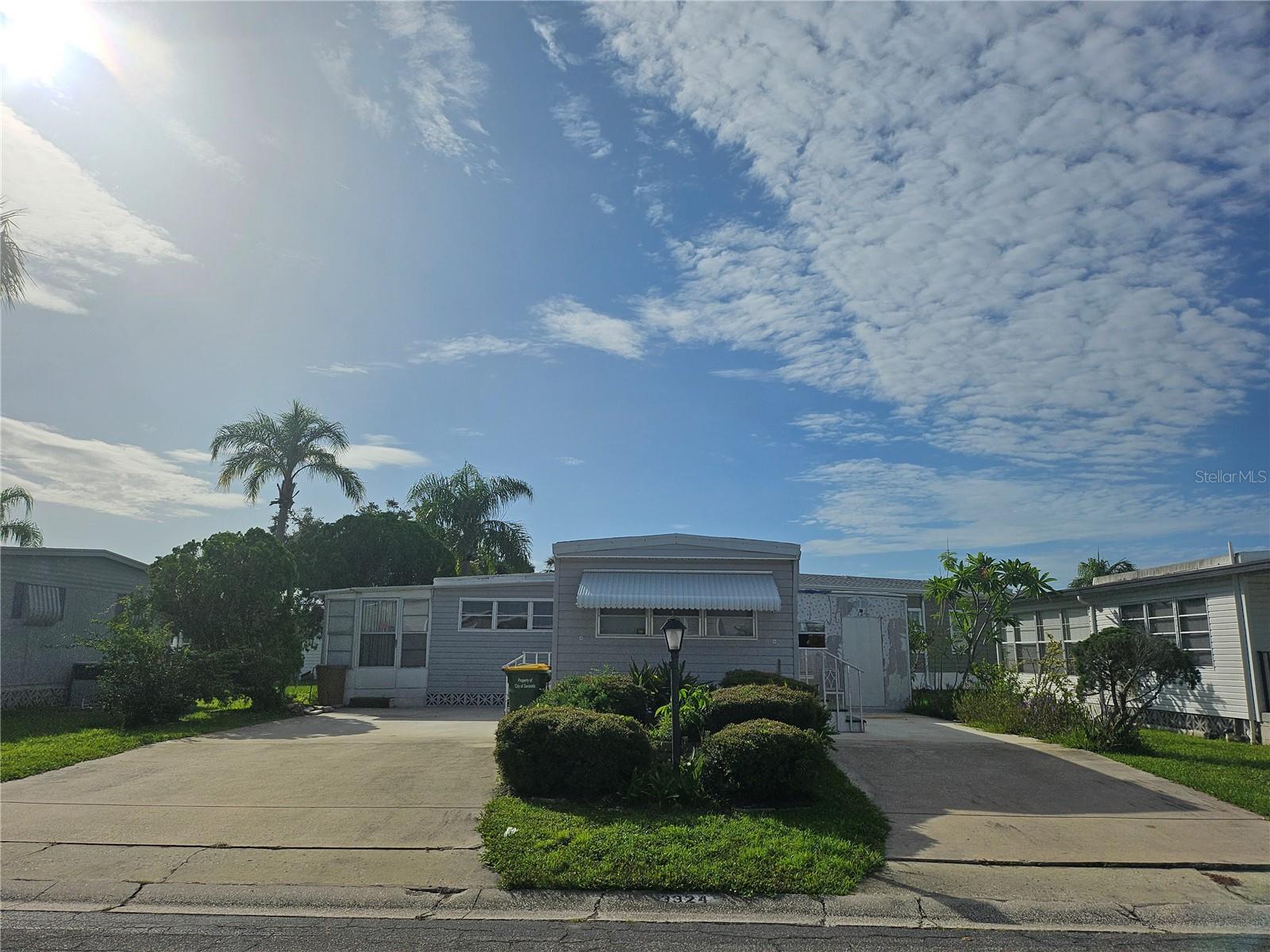 Looking for a lot to bring your new home! Look no further - with this Fantastic lot located at the bridge to Clubhouse/Pool. Priced at lot value!
LOT SIZE 57W X 75D (Buildable space is 47W x 55D). Buyer's developer to remove the current structure.
The current home is a 1 bed / 1 bath with 2 full driveways. Buyers wanting to keep the current home - please note that the HOA requires the buyer to have a contract signed for carport replacement and hurricane damage repair after closing.
HVAC 2019, kitchen remodeled 2011, Vinyl Siding 2008, Elastomeric over shed.
Located in the ONLY Resident Owned Park in the City limits of Sarasota!!
The gated 90 acre community boasts a low maintenance fee with its vast amenities starting with the spacious Clubhouse outfitted with a full commercial cook kitchen, event stage, audio/visual, dance floor, state of the art fitness room, activities hall, library with books/movies/puzzles and a pool table. Outside recreation includes an extra large heated pool with a handicap ramp, a spacious kidney shaped hot tub, ample umbrella tables and lounge chairs and updated shower rooms. Oak trees shade the beautiful park area, picnic tables and a community grill. Additional amenities to enjoy are the community putt putt course, bocce ball, ping pong, horseshoes and corn hole. Oakwood Manor is a vibrant community with numerous social events and activities. Conveniently located adjacent to Legacy Trail and 12 newer pickle ball courts. Just a short drive to our crystal sand beaches, downtown area, the marina, fishing pier, local golf courses, shopping, variety of restaurants, the museum, SRQ airport, SMH and Doctors hospitals. Please note that Oakwood is a 55+, no pet, no motorcycle Park.