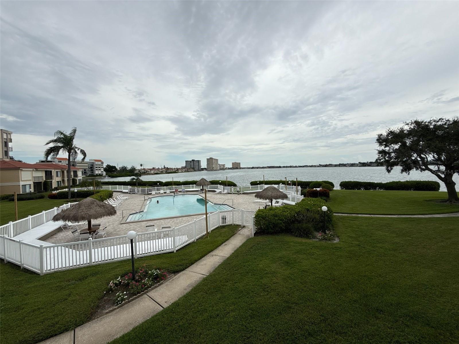 Don’t miss this fully furnished 2-bedroom, 2-bath waterfront villa in the desirable Isla del Sol community. Enjoy stunning views of Boca Ciega Bay and watch dolphins play from your private balcony, accessible from both the living room and guest bedroom. The villa features a bright, airy feel with modern renovations, an in-unit washer and dryer, and a thoughtful open layout. The pool is located just outside the unit for easy access, and covered parking is conveniently nearby. This community offers a relaxing coastal lifestyle near the golf course and marina. Stroll or bike the island, or take a quick ride to Fort De Soto Park, Pass-A-Grille, and St. Pete Beach. Ideally located only 5 minutes from the beaches, 10 minutes to downtown St. Petersburg, and 20 minutes to Tampa. Perfect as a full-time residence or vacation getaway, this villa is available for both annual and short-term rental.