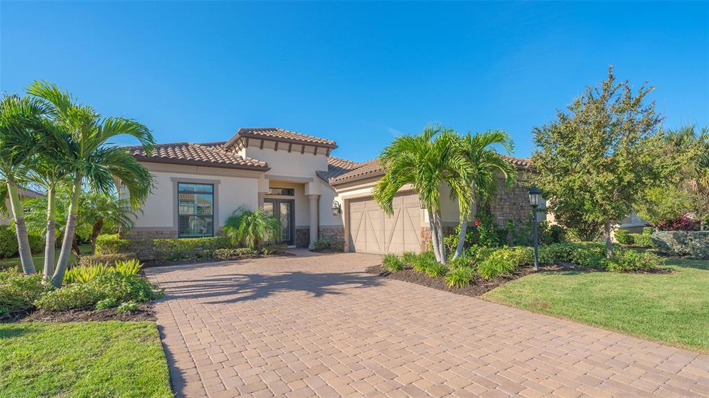 One of Taylor Morrison's great builds in Esplanade of Lakewood Ranch. This singe family home has soaring decorative ceiling through out the entire house with no carpet just upscaled flooring throughout. The volume in this open floor plan is all bright nature sunlight which makes great for gatherings. The dry bar with wine cooler, booze mixer and latte maker is next to the formal dinning area for all of your guest needs. The office/den is delightful with an oversized work space for everyone. Master bedroom has great views overlooking the pool area, greenery and outstanding sunsets. The over sized kitchen is not missing anything for your chef at work with double built in ovens, gas iron cooktop with stainless hood, more then enough tall white cabinets and stone counter top work space galore. Let go outside to the best outdoor living space you could ask for. Nice big covered area with full outdoor kitchen and grilling area with hung TV to watch. No one will be left out as many areas to stretch out on lounge chairs or seating by the fire pit table to enjoy.