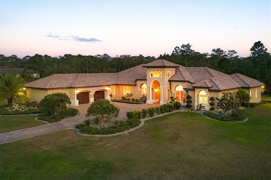 Set on over seven acres in the prestigious equestrian community of Panther Ridge, this custom-built estate offers refined single-story living surrounded by serene preserve views and a private lake. Thoughtfully designed for everyday living and elegant entertaining, the residence spans four bedrooms, four and a half baths, a dedicated office and a spacious bonus room, all underpinned by quality craftsmanship, security of impact-rated windows and front door, and impeccable overall design. A long, private drive leads to a stately entry framed by double-arched, hurricane-rated wood and glass doors with custom ironwork. Inside, high ceilings, architectural detailing, and a combination of rich wood and inlaid tile flooring create a sophisticated yet inviting atmosphere. Expansive windows bring in natural light and connect the interiors to the tranquil outdoor setting. The kitchen is professionally equipped with premium Dacor appliances, including a six-burner gas cooktop, wall oven, microwave drawer, built-in refrigerator and dishwasher. A custom pantry, custom-built breakfast banquette and seamless flow into the living room make this space ideal for everyday use and casual entertaining. A formal dining area is framed by tray ceilings and detailed millwork, offering a timeless setting for special occasions. The home’s guest accommodations include three well-appointed suites, two sharing a Jack and Jill bath, and a third with a private en suite and walk-in closet. A spacious bonus room with vaulted beamed ceilings offers flexibility as a media room, studio or play space. The home office, beautifully designed with custom built-in cabinets, provides a quiet and functional workspace. The expansive primary suite is a private retreat featuring dual walk-in closets and a spa-inspired bath with a freestanding soaking tub, walk-in shower with dual heads, dual vanities and elegant finishes throughout. Outdoor living is equally impressive. The screened lanai includes a saltwater heated pool and spa, an outdoor kitchen with built-in grill and multiple seating areas, all set against a private preserve. Limestone pavers and extensive landscaping elevate the outdoor experience. Additional features include whole-house water filtration and water softener systems, upgraded landscaping and thoughtful storage throughout. Minutes from Lakewood Ranch and close to top-rated schools, dining, shopping and Gulf Coast beaches, this estate offers the rare combination of privacy, luxury and convenience. Panther Ridge is known for its expansive homesites, equestrian trails and peaceful natural setting, making it one of Sarasota’s sought-after communities. This property is more than a residence, it’s an exceptional lifestyle opportunity.