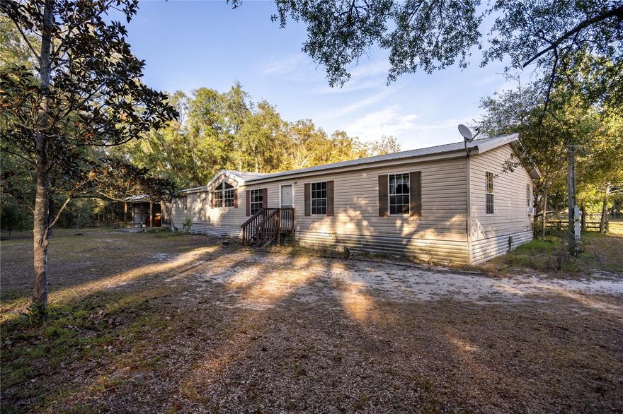 Nestled amidst the picturesque landscapes of Gilchrist County, this spacious 1994 double-wide manufactured home offers the perfect blend of comfort, space, and serene natural surroundings. Situated on a generous 20-acre parcel of land, this property presents an opportunity for a peaceful and rural lifestyle. The 20-acres is crossed fenced with a pasture plus wooded areas for privacy.  The home has a 3 bay carport for your toys plus several out buildings. Don't miss the chance to make this beautiful property your own. Contact us today to schedule a viewing and explore the endless possibilities it holds.