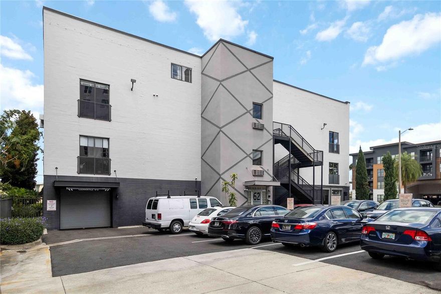 Available for sale or lease! Already inspected and appraised, this property is back on the market after the previous buyer had a change of heart — which means a fresh opportunity for you! Discover a rare blend of history and modern flair in this striking one-bedroom corner loft, set inside one of Downtown Orlando’s most iconic buildings — the former China Glass Warehouse. Originally built in 1930 and converted into lofts in the early 2000s, this residence combines industrial character with artistic modern design. Step inside to find soaring ceilings, exposed brick, heavy timber trusses, and solid steel beams, along with three oversized windows and a double sliding glass door offering a panoramic view of Highway 50 — a feature unique to this corner unit. The sliding door is reinforced with a steel safety grid for added peace of mind. Inside, you’ll find bright Mid-Century Modern styling with a retro diner-style eating area, a touch of Contemporary flair, and standout details like an Art Nouveau chandelier and a 15-foot hand-painted mural along the north wall. The flexible lower level offers open living space ideal for entertaining, creating, or relaxing, while the custom metal spiral staircase leads to a lofted primary area and a private den or office. Enjoy secured garage parking (assigned), extra storage, and guest passes, along with the peace of mind that this building has never lost power during a hurricane in over 20 years. For just $65/month (optional), residents also gain access to Camden’s amenities—including a private pool, patio with gas grills, and stylish lounge spaces. If you’re looking for a distinctive loft that combines industrial roots with modern artistry—and puts you in the heart of Downtown Orlando—this one delivers. Opportunities like this don’t come often.