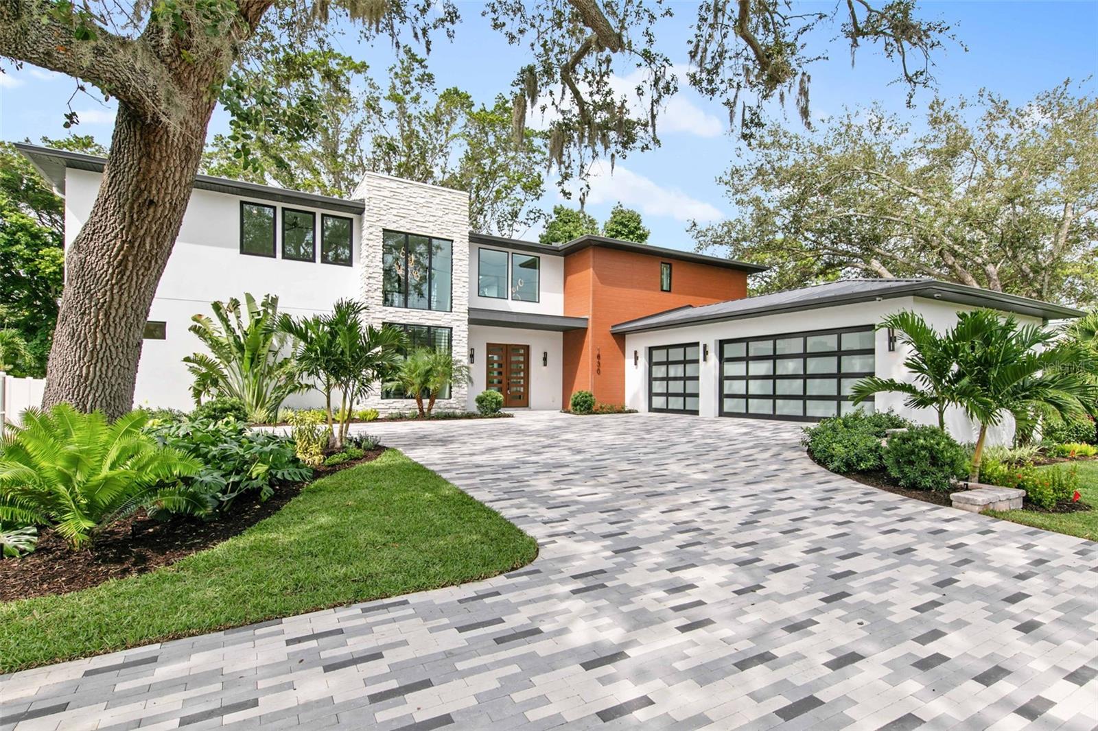 One or more photo(s) has been virtually staged. Welcome to TDI Coastal Homes’ newly constructed masterpiece perfectly situated in the heart of mainland Sarasota, highly sought after for its proximity to top rated schools, the vibrant Southside Village and the arts & entertainment of downtown Sarasota. In addition, the location is central to the beaches and bustle of Lido, Siesta and Longboat Keys as well as the shopping of St Armands Circle. This residence offers the perfect blend of modern sophistication and accessible comfort. Truly designed for indoor and outdoor entertaining, the impressive courtyard and dual lanai surround the pool that features an elevated spa with a rimflow edge, a tanning ledge and a cascading waterfall flanked by two fire features. An outdoor kitchen, 2-sided fireplace, cabana bath and plenty of lounging area, your backyard retreat will be a destination for rest and relaxation. Open the three sets of 8-foot glass sliders and create a seamless blend of the outdoor oasis with the opulent interior. Craft inspired cuisine in the chef’s kitchen featuring a Wolf rangetop, double wall ovens and a Sub-Zero refrigerator and freezer. Fashionable lighting illuminates the quartz countertops draped in a waterfall over the kitchen island with seating for six. A custom range hood is wrapped in handsome walnut wood and flanked by wood shelves. Wine aficionados will appreciate the opportunity to prominently feature their collection in the temperature-controlled wine display with glass surround. Never miss a moment or a memory as the open floorplan connects the spacious kitchen to the ample living room showcasing a feature wall with a gas fireplace, and shelves to display your treasures. Retreat to the generous principal suite, featuring an oversized wardrobe, and pamper yourself in the luxury en-suite featuring beautiful marble walls, dual sinks and a separate soaking tub. Ascend the floating staircase crafted from Florida hickory with a chic, custom wrought iron railing to the second floor offering 3 additional bedrooms, each with a private bath and walk in closet, and an additional flexible space perfect for a media room, playroom, home gym or hobby space. Additional features of this home include a first-floor home office, three car garage, second floor veranda and convenient laundry spaces on both the first and second floor. TDI Coastal Homes creates homes to meet your lifestyle through innovative design and meticulous attention to creating a space that feels extravagant yet effortless.