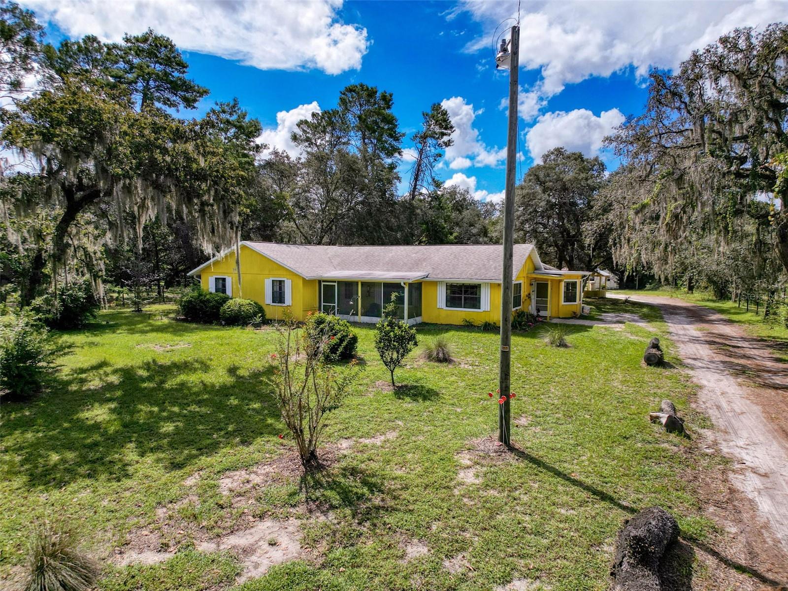 Looking for no deed restrictions? Located on a gorgeous acre of land, this 4 bedroom, 3 bath home is just waiting for its new owners. The flexible floorplan includes a living room, dining room and a bonus room too! Kitchen has been beautifully updated with white cabinets, subway tile backsplash and stainless appliances. The primary suite includes 2 closets and its own updated bath. One of the remaining 3 bedrooms includes an en suite bath too! Huge screened rear porch opens to the relaxing pool area. Floor plan is very flexible. The right side of the home was once used as an in-law suite and has its own entry. The small bedroom was once a kitchen and hook ups are still available for a conversion if needed. Lots of updates including a new holding tank for the well, new pool pump, roof 2020, AC 2021. Plenty of room to store all your toys whether it be boats, ATVs or an RV. Conveniently located with easy access to all amenities. Be sure to put this one on your must see list!