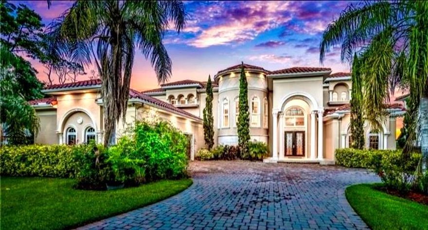 Covers .62 ACRE DIRECT INTRCOSTAL WATERFRONT! This luxurious estate boasts 6,800+ square feet of living, and sits on a Large, oversized lot. No expense was spared in the construction of this 4 bedroom, 4 1.2 bath Tuscany-Italian style, every detail was well-thought-out handpicked and custom designed from the beautiful travertine floor, spiral staircase and Mahogany wood floors. With a custom design and crafted woodwork and cabinetry in the kitchens, bar, Butler's Pantry, closets, and bathrooms. The moment you walk into the front door of this waterfront beautiful home. You will see the fabulous stone compliment the spacious living room and overlook the breathtaking views of the pool + intracoastal waterway. This house was definitely designed with entertaining in mind, as the 24 x 22 kitchen has soft close commercial grade appliances with a 6-burner gas range, double ovens (one convection), and 1 dishwasher. This Double pane, impact resistant hurricane rated windows throughout; concrete block construction (both floor), with the cells being poured every 2 feet, instead of the standard 4 feet; spray foam insulation; tile roof without any compromise of vent stacks, as the venting was designed just below the soffit to maintain the integrity of below, as the venting was designed just below the soffit to maintain the integrity of the roof. The most impressive part of this house is the view! you can either enjoy the magnificent sunrises from the bed of your master suite or balcony, or from the 150-foot dock with boats house and boat slip.