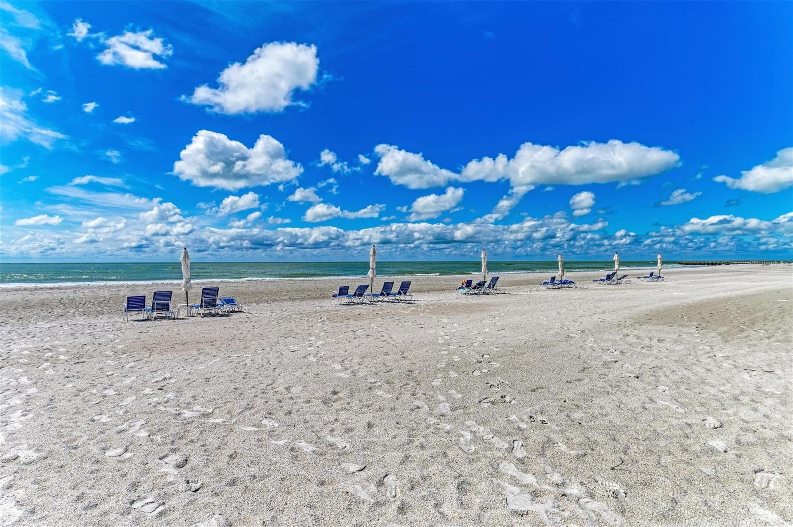 SPECIAL HOLIDAY PRICING. Indulge in the ultimate coastal escape with this rare 3-bedroom, 3-full-bath, turnkey furnished Gulf-front residence—perfectly positioned next door to the St. Regis on Longboat Key. Wake up to sweeping Gulf views, stroll along the pristine shoreline, and relax in a beautifully maintained, amenity-rich environment designed for effortless beach living. Located within the coveted gates of the Players Club, this community has passed all inspections and boasts fully funded reserves, offering peace of mind and long-term value. This home offers a curated blend of modern design and luxurious amenities with all new porcelain plank flooring and LED lighting throughout. The primary suite boasts Gulf views, a spacious walk-in closet with an en-suite bath designed for comfort. A chef’s kitchen features extended built-in cabinetry offering ample storage for culinary essentials and additional seating areas. The open concept living room seamlessly extends to the very spacious balcony, inviting breathtaking beach, tropical landscape and pool vistas, ideal for enjoying spectacular sunsets. There is a nicely appointed large second bedroom providing an amazing guest suite, and the third bedroom styled as a den/home office with a sleeper sofa offering flexibility for additional guests or remote work. Outdoor living is elevated with the expansive screened balcony, creating the ultimate retreat for alfresco dining and relaxation. Enjoy the exclusive lifestyle of this meticulously maintained gated community, featuring a remodeled clubhouse, outside terrace, state-of-the-art fitness center, storage, onsite office, under-building covered parking with plenty of pickleball and tennis courts. The newly renovated pool and landscaping throughout the community is very impressive and you will also enjoy private gulf-front access on a wide beach with sun loungers supplied. The Players Club is on the south end of Longboat Key providing easy access to beach visits, golfing, dining and shopping with a short drive to downtown Sarasota. Peace of mind with an elevated unit, high above the flood plain and the Players Club has passed all engineering and reserve studies with all elevators renovated and certified, and reserves are fully funded. The pool and grounds renovation projects are nearly completed which really makes this a stand-out community. Opportunities like this are few and far between. Don’t miss your chance to own a slice of paradise this holiday season. Schedule your private showing today and make the beach life yours.