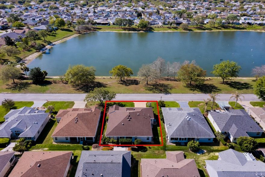 WATER VIEW, 625 sq. ft. OVERSIZED GARAGE (will accommodate 2 CARS & 2 GOLF CARTS - see schematic in photos), GREAT LOCATION, PARTIALLY FURNISHED, NO BOND, and a ROOF REPLACED in 2020…just to get started! Enjoy the SERENITY and WILDLIFE from your SOUTH-FACING front porch and SUNNY Breakfast Nook as you take in the peaceful setting of ASHLAND POND directly across the street! This beautiful BLOCK & STUCCO GARDENIA Designer offers numerous UPGRADES including QUARTZ Counters in the Kitchen, STAINLESS Appliances, ISLAND, Natural GAS Cooktop/Range, abundant Cabinetry (some with glass inserts), Pull-out Shelves, Breakfast Bar and Pendant Lighting. This extremely popular OPEN floorplan features a SPLIT layout with the spacious Primary Suite privately situated on one side of the home with TWO CUSTOM Walk-in Closets and an En-Suite Bath offering TERRA-STONE Counters, His/Hers Sinks, Large Linen Closet and a PRIVACY Door to the CUSTOM TERRA-STONE Shower and Commode. On the opposite side of the home are two Guest Rooms (one without a closet) and a spacious Guest Bath with Tub/Shower Combination, TERRA-STONE Counters and Shower. The main living area is enhanced by VAULTED Knockdown Ceilings, CROWN Moulding and a SOLAR TUBE providing additional natural light. The spacious Living and Dining areas allow for numerous furniture placement options and opens through sliders to the NORTH-FACING GLASS ENCLOSED LANAI, complete with its own Mini-Split for year-round comfort, bringing the effective living space of this wonderful home to approximately 2,145 sq. ft. under heat and air! The thoughtfully designed landscaping provides added PRIVACY in the back of the home. The INSIDE Laundry includes a Washer & Dryer, Utility Tub and another Solar Tube for natural light. Located in the highly desirable Village of ASHLAND, you are LESS THAN 1/10 mile to the Neighborhood Pool and Mail Station, with five additional pools within about a mile, plus nearby Pickleball, Executive and Championship Golf Courses, Recreation Centers, major shopping (including the new Costco), and less than 2 miles to Lake Sumter Landing! Additional features include an Blinds, Window Treatments, Custom Trim, Electric Garage Door Screen, Attic Stairs, Keyless Entry, and the Garage Cabinets and Workbench will remain. The HVAC was replaced in 2018 and the Water Heater in 2017. Tax line reflects property taxes only ($2,484.84). The CDD line reflects the combined annual maintenance and fire district assessments of $725.11. BOND IS PAID! So…what are you waiting for? If not now, when???