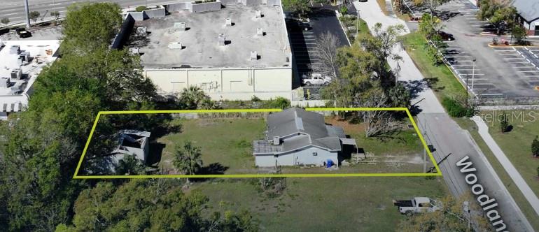 Possible redevelopment or fixer upper. This is one of the last pieces of an important tract for the commercial redevelopment in the area. This block is the lone residential area in a dense commercial area, surrounded by hotels, restaurants, big box retail and the Lakeland Square Mall. It is one of the busiest areas in Lakeland, 2 minutes from I-4 and US 98, a major artery which runs north and south through Lakeland.
.28 acres of land, with a 1,508 SF home, with a built on addition, used for a construction office. The residential portion of the home is no longer occupied, but has 2 bedrooms, 1.5 baths, and a large kitchen with a traditional family room. Work is needed on the property, but the home could easily be renovated to make a rental home.
In addition, there is an approx. 600 SF storage and workshop in the rear of the property. It suffered some roof damage during the recent hurricanes, but could be put back together. Permits have been pulled for the work to be completed.
Almost all of the homes on the block are rentals, and will inevitably be replaced for commercial development. This property is being sold AS IS.