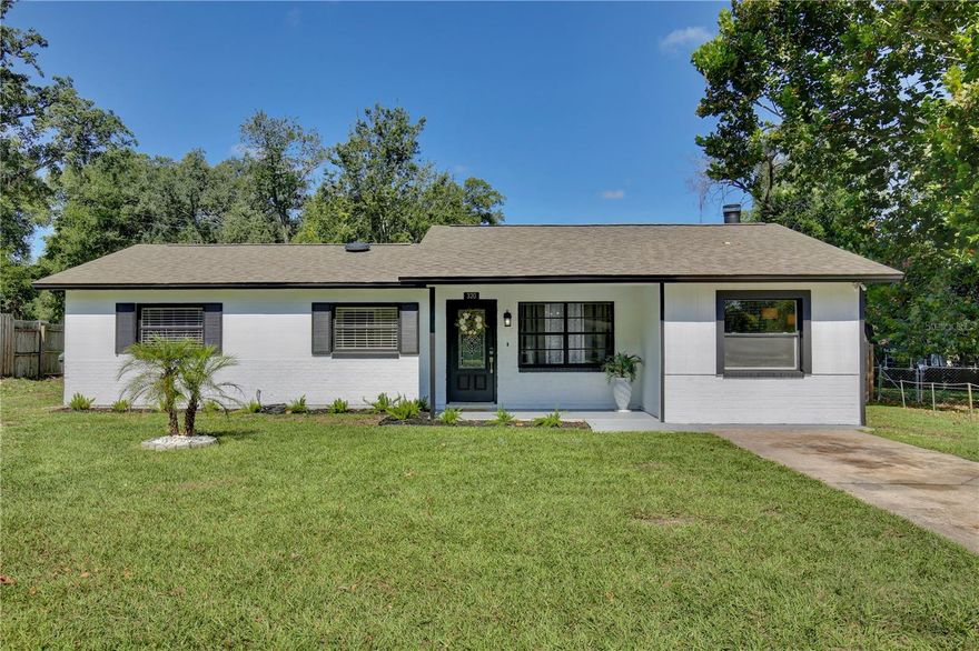 Welcome to your picture perfect abode, a three bedroom home exuding warmth and comfort nestled between Lake Apopka and Wekiva Springs. This home is situated on a large lot, boasting over a third of an acre of green space for your leisure and enjoyment. The welcoming covered front porch guides you to step inside and discover a beautiful interior featuring neutral colors and wood style flooring, crafting a versatile backdrop for your personal décor. The living room invites relaxation with its chic whitewash brick fireplace, complete with a stately mantle. Entertaining is a breeze in the dining area illuminated by a rustic chandelier, with the convenience of pantry storage, laundry room access, and sliding glass doors that open to the expansive family room. The light and bright kitchen is equipped with stainless steel appliances, recessed lighting, elegant countertops, and a built in oven, along with views of the backyard. Retreat to one of the three airy bedrooms, each offering mirrored closets. The bathroom is nothing short of stunning with floor to ceiling tile and an LED mirror. The huge fenced in backyard is a canvas for your outdoor dreams, providing ample space for a fire pit, pool, or personal garden oasis. Located near the beauty of Lake Apopka and the natural springs of Wekiva, this quiet neighborhood is conveniently close to essential shopping, dining, and main roads including 441 and 429. Embrace the Florida lifestyle, from weekend manatee sightings to nature trail hikes and fresh water fishing. Explore the 3D tour and seize the opportunity to make this house your new home, schedule a showing today!
