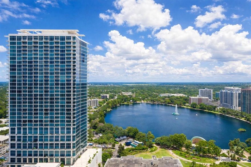 A statement in style at The VUE, Residence #802. Step into a residence that feels more like a curated editorial home than simple a condo. This one of a kind corner loft at The VUE offers a rare expression of modern luxury, designed for those who appreciate elevated living with a fashion forward edge.  Framed by dramatic 20 foot floor to ceiling glass walls, the space is filled with natural light and showcases breathtaking sunset views over Lake Eola and the Downtown Orlando skyline from every angle.

Every detail has been thoughtfully reimagined. The residence features sleek 24 inch high gloss tile throughout, creating a seamless and sophisticated backdrop. The designer kitchen is both refined and functional with matte fingerprint resistant cabinetry, modern fixtures, deep sink, custom backsplash, track lighting, stainless steel appliances and a gas range, perfectly suited for entertaining and everyday living.

The open concept living space is anchored by a striking crystal chandelier that adds a sense of glamour and refinement. Sixteen custom motorized shades allow you to effortlessly control light and privacy, whether you are showcasing the skyline or creating a more intimate setting. The expansive wrap around balcony serves as an extension of the living space, offering the perfect setting for morning coffee overlooking Lake Eola or unwinding at sunset with sweeping city views. Upstairs, the lofted primary suite offers a private retreat with ample space for a California king bed, custom built in closets and tranquil elevated views. The spa inspired bathroom features a custom walk in shower, updated cabinetry and a contemporary LED mirror. Additional features include smart home integration with a Nest thermostat, in unit washer and dryer, and one assigned parking space. The residence has been fully upgraded throughout.

The VUE at Lake Eola is Downtown Orlando’s premier glass high rise offering a full service lifestyle with 24 hour concierge, security, resort style pool with brand new shaded cabanas, state of the art fitness center, tennis courts, basketball courts, club room, valet guest services and EV charging stations.

Located just steps from Lake Eola Park, the Dr Phillips Performing Arts Center, KIA Center, Inter and Co Stadium, and Orlando’s top dining, nightlife and cultural experiences, this residence delivers unmatched walkability and convenience.

Residence #802 is rare, refined and truly one of a kind, offering the ultimate in luxury downtown living.